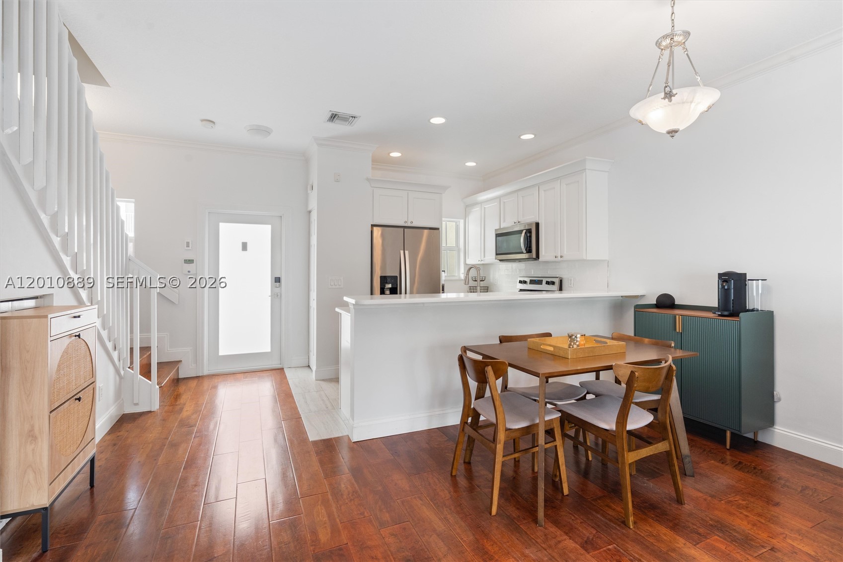 Private gated townhome in Victoria Park featuring an open-concept kitchen with quartz countertops, breakfast bar, stainless steel appliances, and custom cabinetry. The main living/dining area includes Brazilian cherry hardwood floors and a half bath on the first floor. Upstairs offers two primary suites with vaulted ceilings and en-suite bathrooms, plus a full-size washer and dryer. Enjoy a private brick-paver patio ideal for outdoor dining and entertaining. Two assigned parking spaces directly in front. Located in East Victoria Park near Las Olas Blvd, Galleria Mall, Fort Lauderdale Beach, and more.