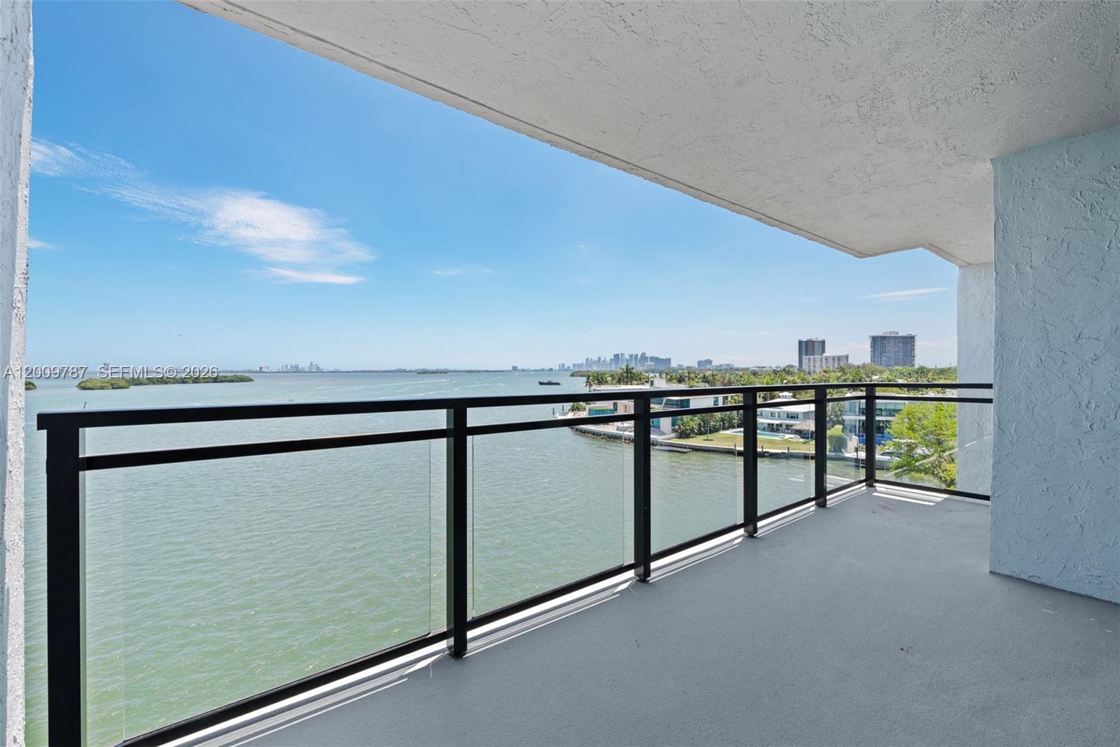 This 7th-floor penthouse at Coral Bay Racquet Club offers direct, unobstructed views of Biscayne Bay from the living room, primary bedroom, and two private balconies. The unit spans 1,203 square feet with 2 bedrooms and 2 bathrooms.

Polished marble floors run throughout the unit. One bedroom has been opened to the main living area, creating a large open-concept space with additional natural light and bay views. The second bedroom remains fully enclosed with direct access to a private bay-view balcony. The kitchen features wood cabinetry, light-toned countertops, stainless steel appliances including a French door refrigerator and built-in microwave, and a bay-view window over the sink. Both bathrooms include single-sink vanities with marble surfaces and ample storage. The primary bathroom features a bay-view window, a glass-enclosed travertine tile shower, and a walk-in closet. An in-unit stacked washer and dryer is included.

Fully equipped with Miami-Dade certified impact windows and glass sliders throughout. Both private balconies boast the same sweeping, unobstructed views, overlooking Biscayne Bay and nearby mangrove islands, with Miami Beach in the distance and a south-facing sightline of the city skyline.

Building amenities include a swimming pool and tennis courts. Located minutes from Wynwood, the Design District, Miami Beach and Downtown Miami.