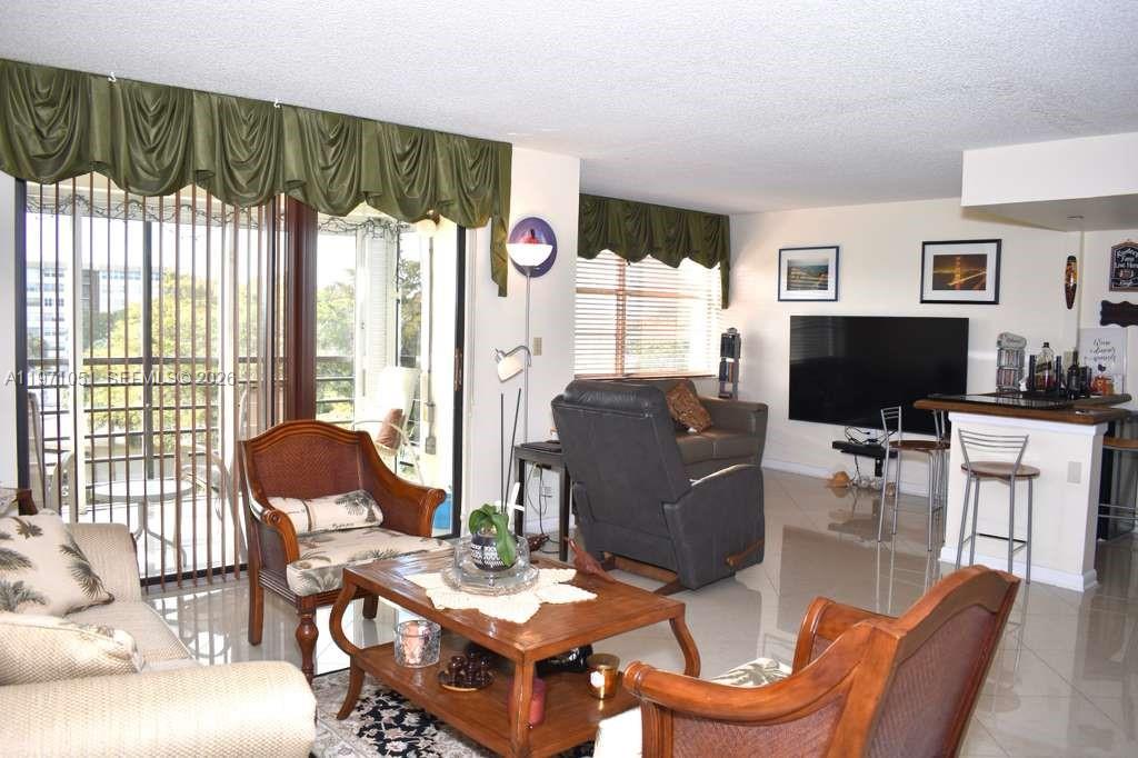 Beautifully remodeled and kept BANYAN unit, with modern decor. This is the largest model in the building, with the 3rd bedroom opened into a den with a bar! The guest bedroom with a walk-in closet is currently set up as an in-home gym and office, and contains a Murphy bed to allow for space and visitors. Kitchen and bathrooms renovated. The primary bathroom features a powder room, a walk-in shower with modern tiles, and three closets, two of which are walk-in. The kitchen has stainless steel appliances, a large dining table, and a spacious pantry. The main flooring extends to the screened patio with electronic sun shades and features large porcelain tiles set diagonally. The bedrooms are finished with wooden flooring. Lots of closet space throughout the unit. Just move right into this very desirable Park Place community, which has expansive landscaped grounds overlooking the Pembroke Pines course and Park Place tennis courts. Newly landscaped park. Amenities include, library, tennis courts, clubhouse with activities, both internet & cable, water, gym, a sauna and 4 heated pools.  There is a scenic jogging/walking path around the gated community. Laundry room on the same floor. The unit even has a parking space close to the front door. This is a 55+ a community with many activities for residents.  The 2nd resident must be 19+, and the association requests 20% down. CONV is allowed, and rentals are allowed based on capacity. Furniture negotiable.