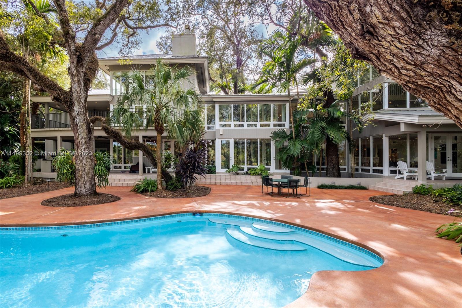 Serene 14,447 SF lakefront estate on 2 acres in gated Hammock Lake, with 8-BD, 8-BA, 2-HB, and a guest apartment with kitchen and separate entrance. Features include a grand entry with volume ceilings, floor-to-ceiling windows providing ample natural light, white oak floors, double-wide hallways, elevator, Control4, generator, and impact windows and doors. A true chef’s kitchen offers ample counter space, two islands, premium appliances, and pantry. The home is a natural extension of its environment, seamlessly blending with the lush outdoor landscape, while providing picturesque views of live oaks, sabal palms, palmettos, and ferns. Includes a lagoon-like pool, fire-pit, summer kitchen, and dock with lake access.