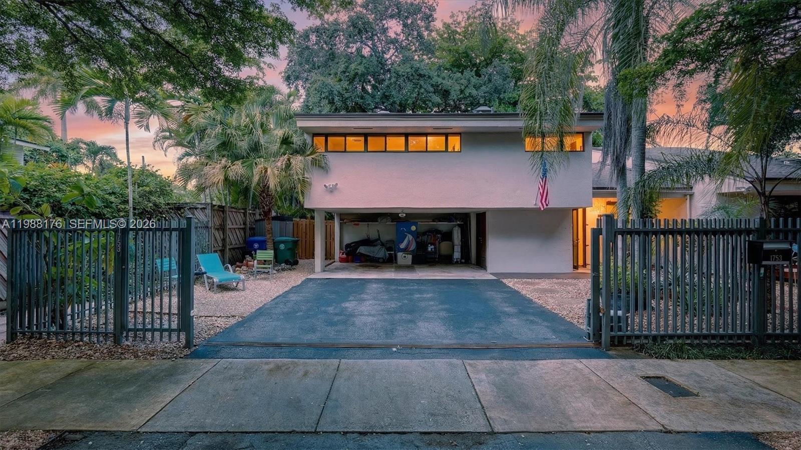 Discover the essence of North Coconut Grove living in this exceptional residence set on a spacious, lushly landscaped lot; which sits on a ridge of roughly 18’ above sea level and carries No Flood Zone Designation. Blending privacy with everyday convenience, this light-filled home offers an airy, open layout with expansive interiors and a striking glass gallery that frames views of the tropical backyard and large wraparound deck. Outdoors, a secluded garden creates a true oasis, perfect for gatherings or quiet retreat with enough room for pool. Ideally located in the highly sought-after North Coconut Grove/Nocatee area, the home is just minutes from Biscayne Bay, Brickell, Coral Gables, and I-95, along with top-rated schools, parks, and local cafes. Complete with a two-car carport, large privacy wall with metal gate this property presents a rare opportunity to enjoy the serene Grove lifestyle on one of its most desirable streets.