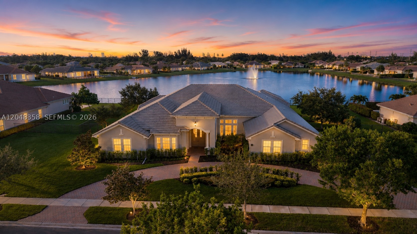 Rarely available perfectly positioned on the best and most desirable water-front lot in the ultra-exclusive gated luxury community of Sterling Ranch….this exceptional estate features some of the longest, most panoramic water views in the neighborhood capturing fantastic South Florida sunsets. Offering over 5,000sq. ft. of living space, this one-of-a-kind residence features 4 bedrooms, 4.5 bathrooms, a spacious game room with a full kitchen and private entrance, plus an additional versatile room that can easily serve as a 5th bedroom, home office, or media room. The chef's kitchen is designed to impress with a spectacular 16-foot island, premium Sub-Zero refrigerator and freezer, custom cabinetry, and abundant workspace. Walls of impact-resistant windows and custom French doors flood the home with natural light while framing breathtaking waterfront and sunset views throughout. The oversized primary suite offers a private retreat with spa-inspired finishes and direct outdoor access. Positioned forward on the oversized homesite, the property provides exceptional backyard space to create your own resort-style paradise with room for a custom pool and outdoor entertaining. Built with exclusive builder upgrades, additional highlights include an oversized 3 car garage, hurricane-impact windows and doors throughout, and a 6-foot safe. Ideally located between Fort Lauderdale and Miami with convenient access to major highways, shopping, dining, and entertainment