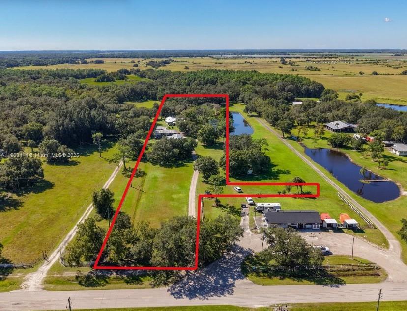 INVESTOR’S DREAM, FAMILY COMPOUND, & RURAL RETREAT IN ONE! 4.5 ACRES OF SCENIC BEAUTY – 3 RESIDENCES – 2 POLEBARN/GARAGES - SO MUCH POTENTIAL! Whether renting residences and barn/garage buildings for investment or utilizing as a family compound or a little of both, here is your opportunity for a smart investment or a nature enthusiast’s retreat! This breathtaking 4.5 acres includes half of a tranquil pond and boasts wildlife friends including wood storks, Elvis, Priscilla and Lisa Marie and wild turkeys, Tom, Jerry and Dale! Main home is a CBS with galvalume roof and is a 2/2, built in 1980. Home enjoys a full length front screened porch and open rear patio for barbecuing.
