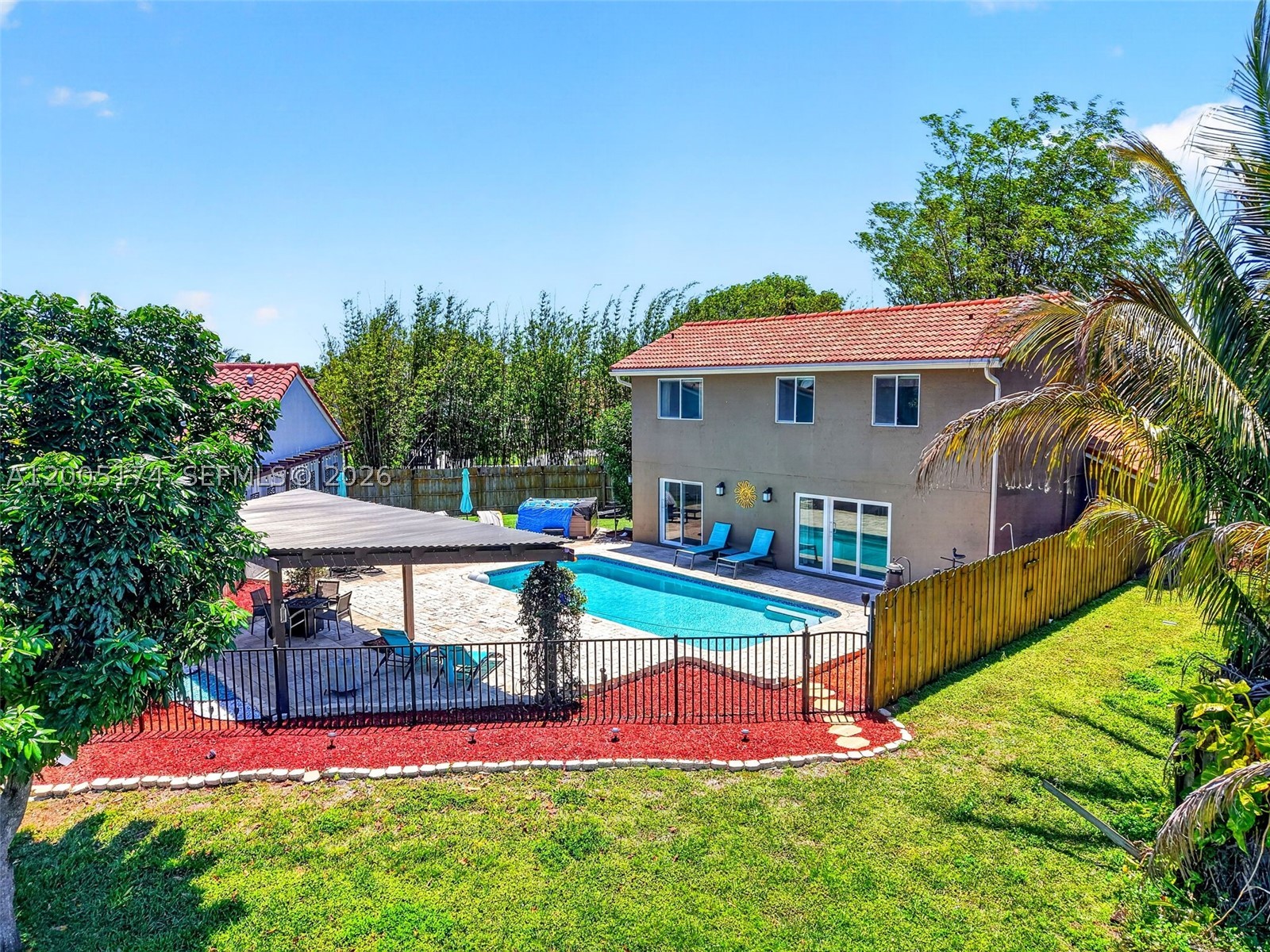 Experience elevated lakefront living in this beautifully updated home in the sought-after Country Fair community of Boynton Beach. Set on an oversized lot with approximately 50 feet of serene waterfront, this residence offers a rare blend of privacy, style, and resort-inspired outdoor living. The backyard is a true showpiece—featuring a sparkling pool, expansive paver deck, and covered pergola—perfect for entertaining or unwinding while enjoying tranquil water views and breathtaking sunsets. Inside, a light-filled, open layout showcases clean lines, neutral finishes, high ceilings, and a functional two-story design. The kitchen offers generous cabinet space, a snack bar/counter area, and easy flow into the main living and dining spaces. The spacious primary suite serves as a private retreat with en-suite bath, while additional bedrooms offer flexibility for guests, family, or a dedicated office. Built with concrete block construction and complete impact glass, the home provides both durability and peace of mind. A two-car garage, laundry room, extra storage shed, and access to community amenities—including clubhouse, pool, and security—enhance the lifestyle. Lakefront pool homes at this price point are rarely available—schedule your private showing today.