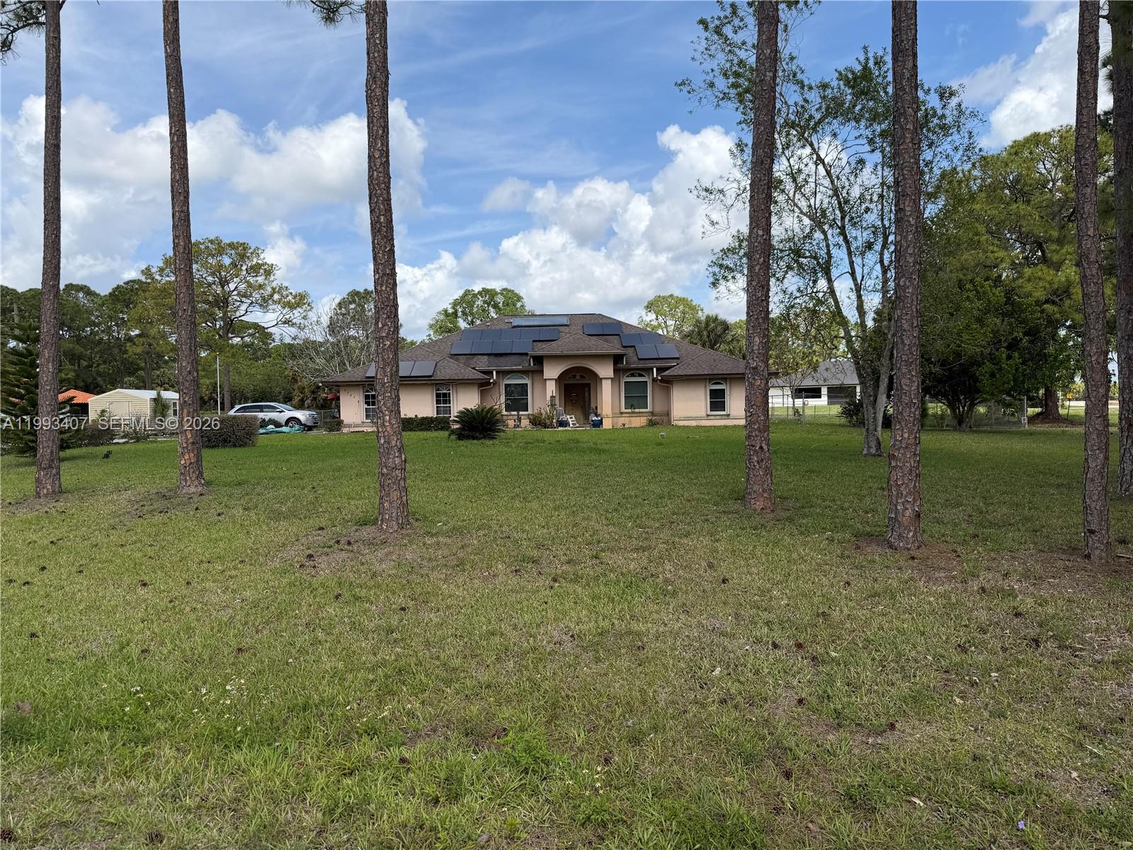 WONDERFUL PROPERTY WITH 4 BEDS AND 3 BATHS LOCATED IN THE ACREAGE. COUNTRY LIVING IN THE CITY WITH A 1.54 ACRES FULLY FENCED YARD. NEAR MAJOR ROADS AND HIGHWAYS, NEW PUBLIX SHOPPING PLAZA WITH NEW STORES AND RESTAURANTS JUST A FEW MINUTES AWAY. MANY UPGRADES INCLUDING SOLAR PANELS MAKING YOUR ELECTRIC BILL ABOUT $32 A MONTH, WATER HEATER HAS OWN SOLAR PANEL, IMPACT WINDOWS WITH ACCORDION SHUTTERS, AUTOMATIC SPRINKLERS, ROOF INSTALLED 2023, OPEN FLOOR PLAN WITH PLENTY OF SUNSHINE COMING IN, GREAT FOR FAMILY OR ENTERTAINING.  CALL TO SHOW. NO HOA.