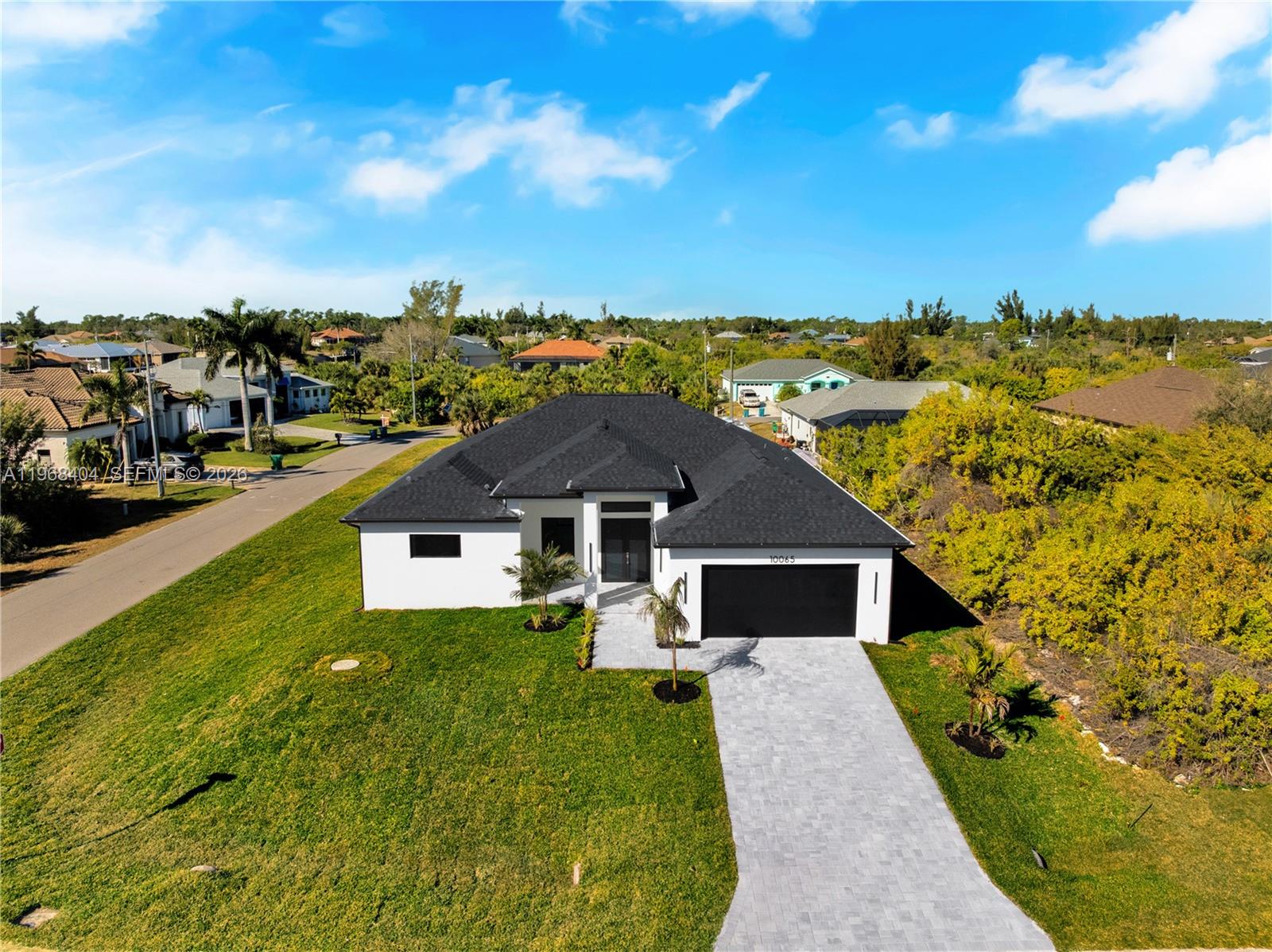 Brand-new construction with a clean, modern coastal vibe in Port Charlotte! This thoughtfully designed home welcomes you with a sleek facade, and a wide paver driveway that elevates curb appeal from the start. Inside, enjoy a bright open concept layout with large format tile flooring, recessed lighting, contemporary finishes, and an oversized chef’s kitchen featuring a statement island, modern cabinetry, and stainless-steel appliances perfect for entertaining and everyday living. The primary suite feels airy and relaxing, and the home includes a dedicated laundry area for convenience. Move-in ready, fresh, and built for today’s lifestyle schedule your private showing!