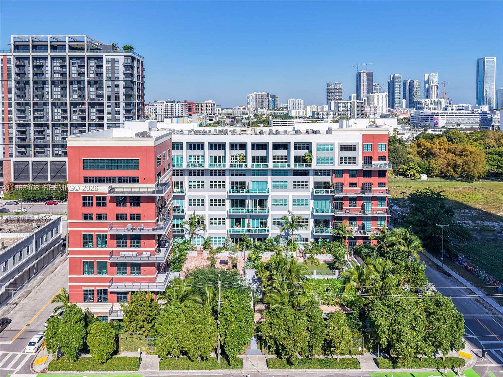 A truly rare offering, this authentic industrial loft at Parc Lofts, unit #605 delivers a level of scale, design, and character that is virtually unmatched in Miami. Defined by dramatic 20-foot ceilings and expansive, voluminous interiors, this residence offers a bold architectural presence rarely found in newer construction. The custom-designed 2-bedroom, 2.5-bath layout blends luxury with urban edge, featuring sleek ceramic floors, bespoke built-ins, and a refined chef’s kitchen with high-end finishes and striking design elements. A dedicated formal dining area anchors the space, making it ideal for entertaining while preserving the openness of true loft living. An open den and office flex space on the second level adds a highly functional and design-forward element, perfect for a home office, creative studio, or additional lounge area. Set within a boutique, full-service building, residents enjoy a curated lifestyle with a resort-style pool, fitness center, on-site management, and two assigned parking spaces. The intimate scale of the building enhances privacy and exclusivity. Perfectly positioned in central Miami, moments from Wynwood, Midtown, the Design District, Miami Beach, Downtown, Brickell, and Miami Int.l Airport, this home offers unmatched connectivity. Bold, chic, and undeniably unique—there is simply nothing else like it in Miami. Don’t miss this exceptional opportunity to own a one-of-a-kind property rarely available in today’s market! See broker remarks.
