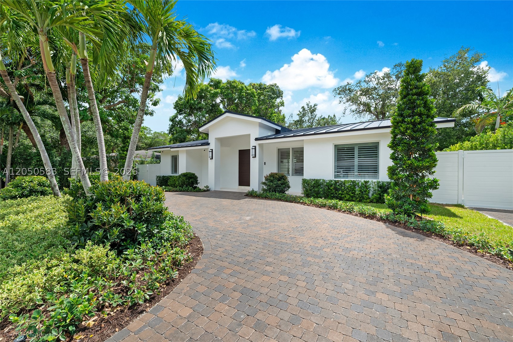 Masterfully rebuilt and expanded in 2026, this exceptional 4-bedroom, 3.5-bath residence offers timeless design, refined finishes, and effortless indoor-outdoor living in one of South Miami's most desirable neighborhoods. A charming front porch and circular driveway welcome you into light-filled interiors featuring soaring ceilings, oversized porcelain tile, rich hardwood floors, plantation shutters throughout, and an open-concept layout ideal for entertaining.

The designer kitchen showcases quartz countertops, custom wood cabinetry, integrated and premium stainless steel appliances, a statement range hood, wine cooler, and a generous island overlooking the living and dining areas.

The serene primary suite features two custom walk-in closets, direct pool access, and a spa-inspired marble bath with dual vanities, soaking tub, and oversized glass-enclosed shower. Three additional bedrooms include one en-suite, while a cabana bath provides convenient access to the outdoor living spaces.

The private backyard is designed for year-round enjoyment with a newly constructed pool, covered terrace, lush landscaping, smart irrigation, security cameras, and a fully fenced yard. Additional highlights include two central A/C systems, a dedicated laundry room, and exceptional craftsmanship throughout. A rare turnkey opportunity offering contemporary luxury and the best of South Miami living.