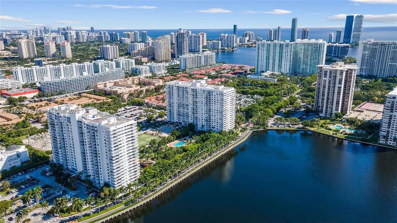 2 BED 2 BATH!!!! Stunning Renovated Corner Unit with Wrap Around Balcony with Panoramic Lake Maule and Skyline View!!! Unit Is Tastefully Renovated with Modern Open Concept, Huracan Shutters and The Most Beautiful View from Every Window. Building With Great Resort Style Amenities, 2 Heated Pools, Tennis Court, Mini Golf, Basketball Court, Gym, And Modern BBQ Area.24 Hrs. Concierge. 1 Covered Parking Space and An Extra Parking Space Uncovered. Withing Walking Distance to Shops and Restaurants, Minutes from Aventura Mall. Unit Comes With 1 Covered Parking Space.