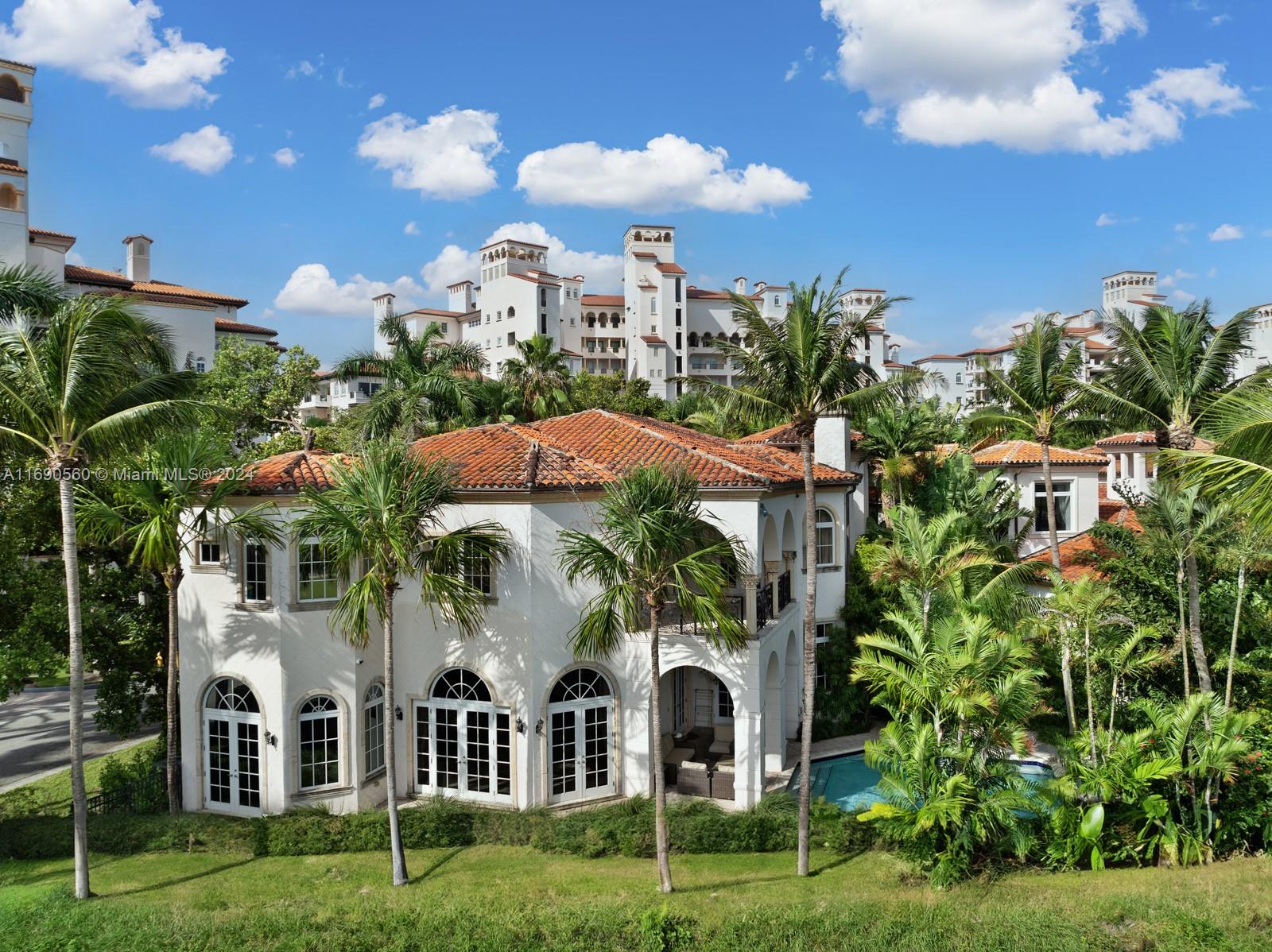 Welcome to your exclusive sanctuary on Fisher Island! Surrounded by lush tropical gardens, this home offers a serene escape into resort-style living. Enter into to a grand, light-filled space where sophisticated design meets comfort, highlighted by elegant crown moldings, and polished marble floors. An airy flow carries you through arched doorways into the inviting family room, where a beautiful fireplace and French doors reveal a picturesque poolside view. Outdoors, your private oasis awaits with a sparkling pool, spa, and expansive coastal views that capture the essence of relaxed, refined living. Spanning approximately 7,137 sq ft, with 6 bedrooms and 6.5 bathrooms, this residence embodies the ultimate island lifestyle.