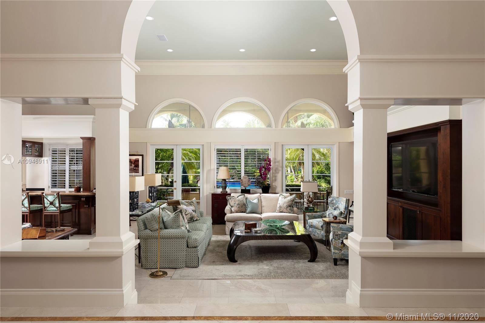 Rare opportunity to own an expansive gated estate on almost 2 acres in the prestigious Village of Pinecrest. A blend of elegant and traditional styles, this spacious home with grand ceilings unites in the light-filled great room. A wet bar connects the oversized chef's kitchen equipped with top of the line appliances and skylight. Split floor plan separates 4 bedrooms and library from the opulent master wing, complete with home office, gym, outdoor sauna and steam room. Abundant outdoor entertainment spaces featuring loggia, pool/spa, pavilion with summer kitchen and cabana bath, chickee hut, tennis court and canal access encompassing a serene tropical garden paradise; 3-car garage and ample space for guest parking. Superb private and public schools nearby. A private haven awaits you here!