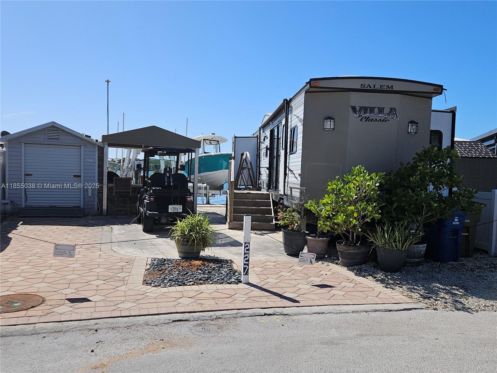Breathtaking bay views from your own backyard. RV lot in Calusa Campground with two boat lifts, one 10K lbs. the other 7K. 45' long Salem Villa Park Model trailer with 4 slide outs, 2 bedrooms, one and a half bath. 4 a/c’s, full size refrigerator. Furnished ready to move in. Covered outdoor kitchen & cool deck throughout. All done with permits! 10 x 8 storage shed. Golf Cart included. Use it as a weekend get-a-way or rental income. Calusa is one of the few communities in the Keys that allow short term rentals. Amenities like a marina/boat ramp, dockage, storage, security, tennis and basketball court, playground, laundry, pool. The property is close to several restaurants, shopping, entertainment... ** Owner financing available with a good down payment ** Come see it and you will love it!