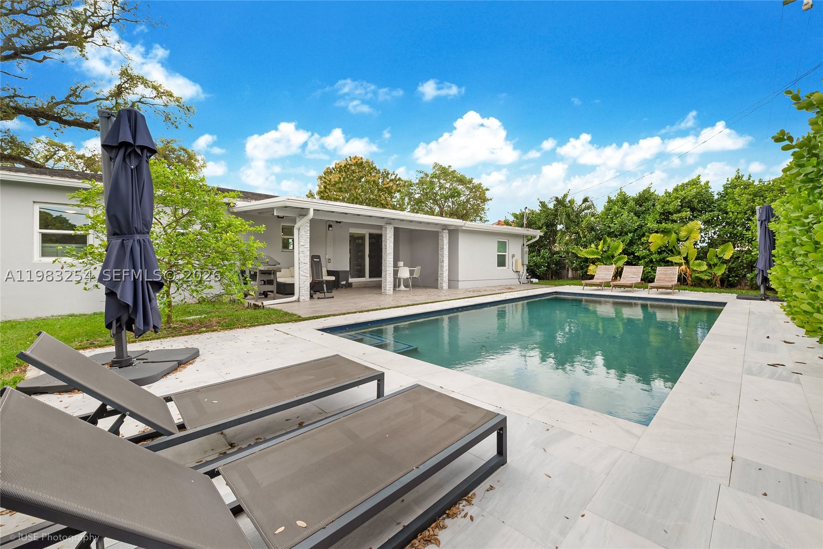 Welcome to this beautifully fully renovated residence, where modern elegance meets comfort and functionality. Thoughtfully redesigned with high-end finishes throughout, this home offers a bright and open floor plan that cretas an inviting and airy atmosphere from the moment you step inside.

The entrance and kitchen both showcase lovely views of the garden and pool, bringing natural beauty and light into the heart of the home.  The kitchen and bathrooms are appointed with luxurious marble countertops, combining timeless style with everyday practicality. The primary bathroom also features a Roman bathtub, perfect for relaxing in a spa-like setting after a long day.

Step outside to enjoy your private backyard oasis featuring a heated saltwater pool, perfect for relaxing or entertaining all year-round.  The property is enhanced by mature fruit trees, adding charm and a touch of nature as well as a convenience storage shed for additional space.

Additional upgrades include impact windows for safety and energy efficiency, along with a roof that is less than five years old, offering peace of mind for years to come.

For those seeking a move-in ready opportunity, the home can be offered fully furnished at the right price, making it ideal as a primar residence, seasonal retreat, or investment property.

This exceptional home truly combines style, comfort, and convenience in a beautiful setting.