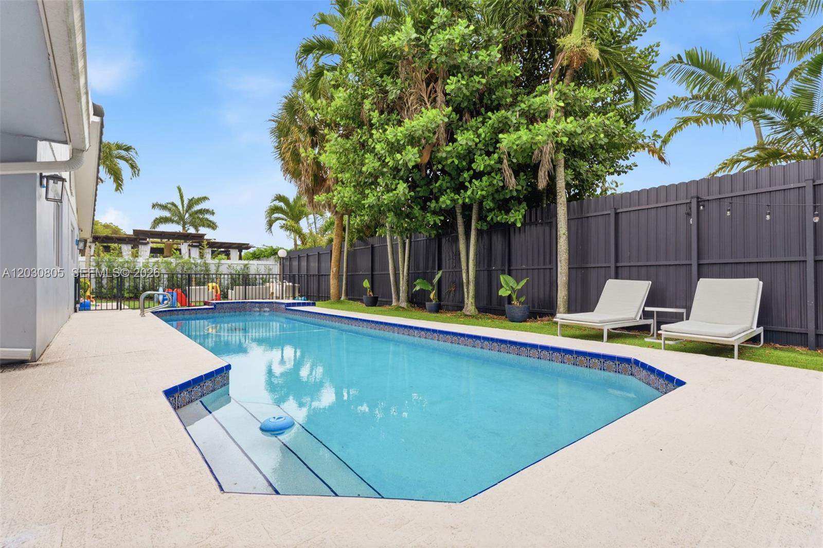PRICED TO SELL in Country Club of Miami Estates! This beautifully updated 3-bedroom, 3-bath residence offers the perfect blend of comfort, style, and South Florida living. The open floor plan seamlessly connects the living, dining, and family areas to a spacious kitchen with oversized island, creating an ideal setting for everyday living and entertaining. The luxurious primary suite serves as a private retreat featuring a renovated spa-style bathroom with soaking tub, separate shower, dual vanities, and a custom California Closet. Impact windows and doors, a newer roof (approximately 10 years old), heated pool, circular driveway, and 2-car garage complete this exceptional home. Located within the private guard-gated community of Country Club of Miami Estates with 24-hour security and roving patrol, this property offers a unique opportunity to enjoy one of Miami-Dade's most sought-after neighborhoods.