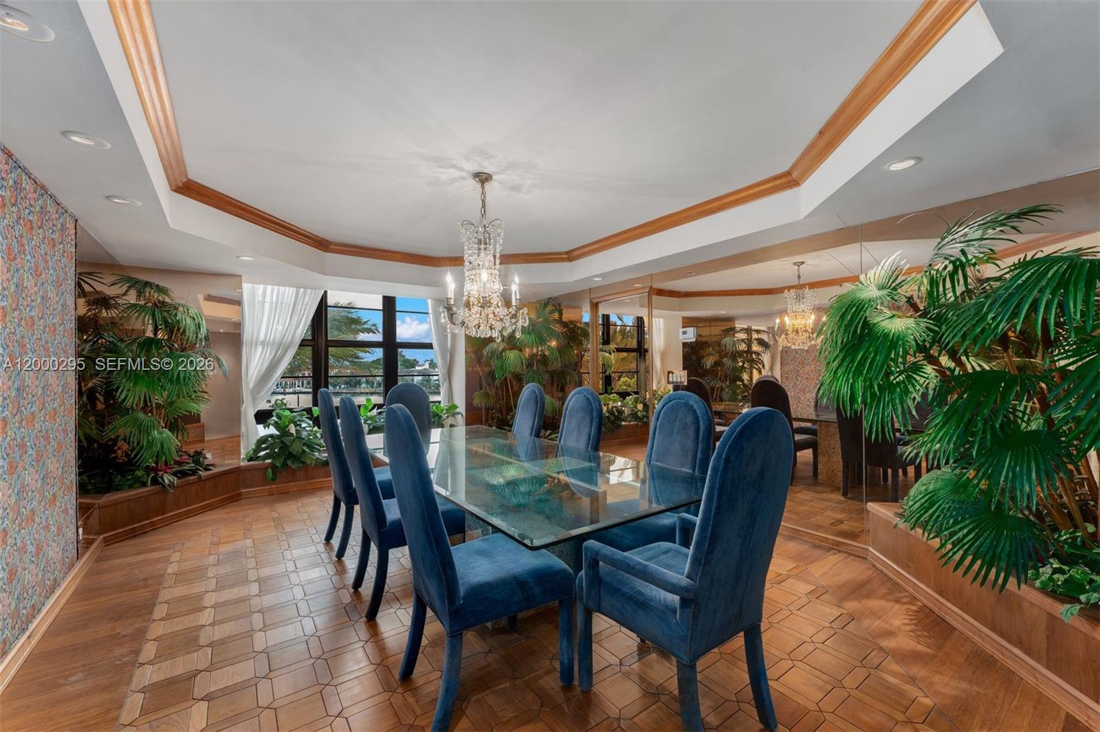 Corner unit in immaculate condition showcasing beautiful millwork, rich wood, and a Retro Miami Glam style, with stunning Intracoastal views overlooking the pool. The spacious living area opens to the wraparound balcony and flows into the dining room and kitchen, all capturing water views. Just off the kitchen is an in-unit washer and dryer, and a generous library/den with a wet bar adds great flexibility. The primary suite offers two walk-in closets and dual bathrooms, while the second bedroom features its own ensuite bath, along with a separate powder room for guests. Additional private storage is located outside the front door. The building features outstanding amenities, including a waterfront pool, tennis courts, a club room, gym, sauna, and an on-site restaurant.