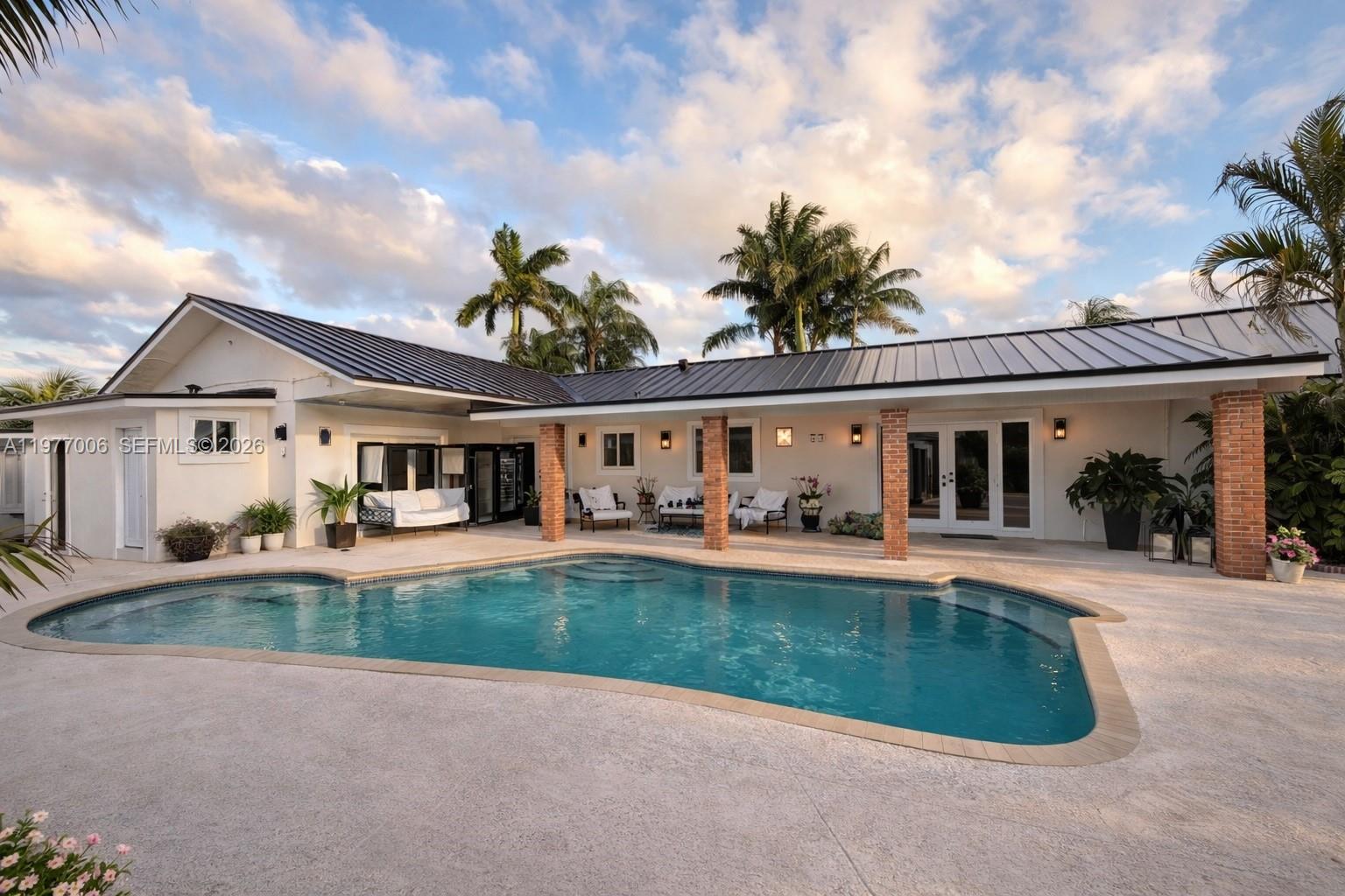 Welcome home to this spacious 3 bedroom plus office or optional 4th bedroom, 3 bathroom corner home located in a quiet Miami neighborhood. The property offers two parking areas with motorized gates, including a covered carport and approximately 2,105 sq ft of living space with a functional layout. The home features a welcoming foyer entry, bright living areas with French doors, and abundant natural light. The kitchen connects seamlessly to the formal dining and family room, ideal for everyday living and entertaining. Impact windows provide added comfort and security. Step outside to a private backyard oasis featuring a covered patio, tiki hut and pool, perfect for relaxing or hosting gatherings. Additional features include a laundry area and generous outdoor space. Conveniently located near major roads, shopping, dining, and schools. Pets welcome with fee. The garage has been converted into a private efficiency with separate side entrance and the current lease runs through April 2026. The owner is open to keep it as storage for his furniture at $4,500, rent the entire home to the same tenant including efficiency for added privacy at $5,000.