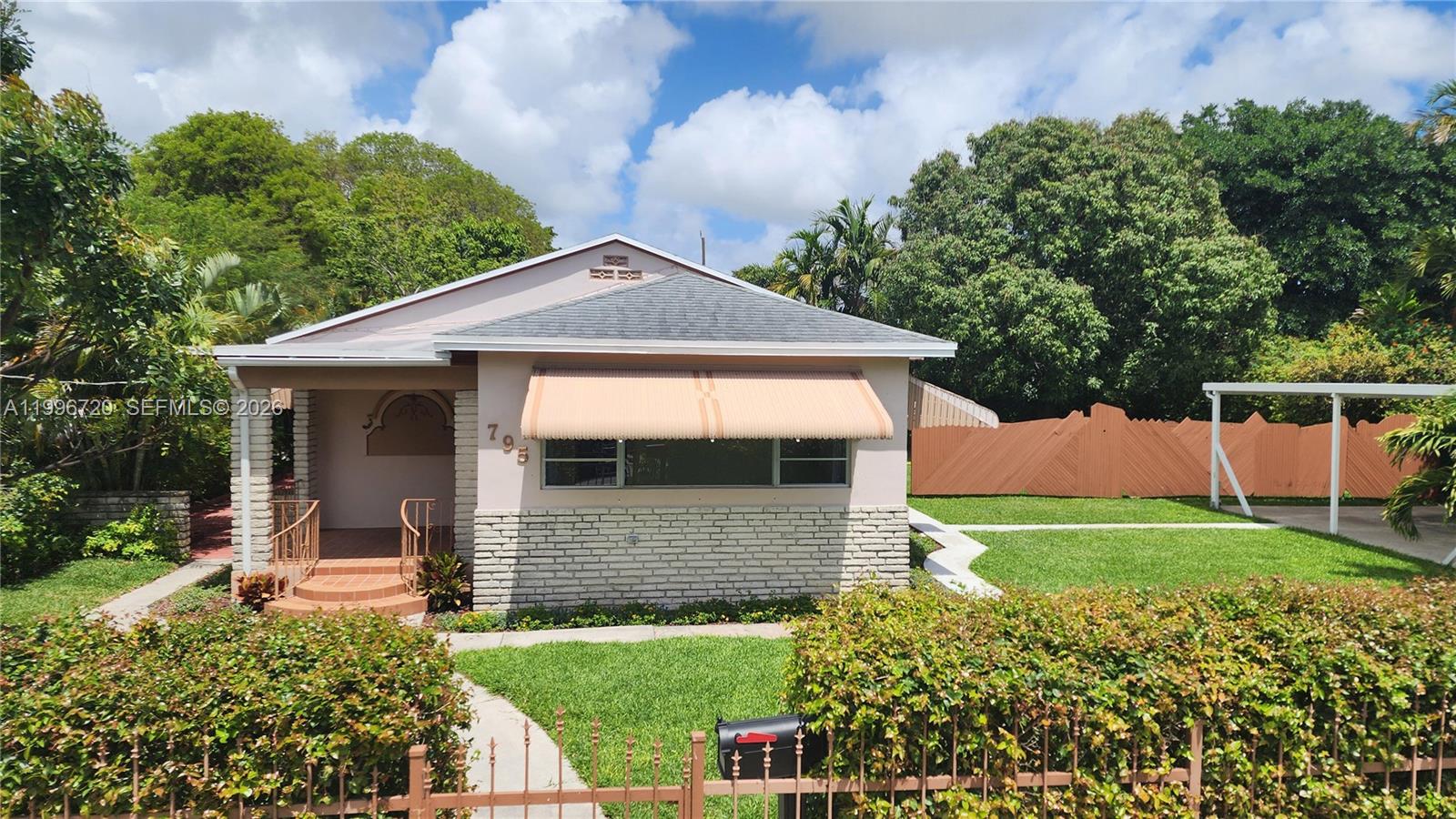 Actual bldg sf per city 2,109. Agents welcome. Rare corner double-lot home bordering Buena Vista and Wynwood in quiet Hadley Park. Move-in ready, no deferred maint. On slab Flood Zone minimal (Zone X, 11’ elev). Pass through the classic wrought iron fence & gate into this 10,000 sf property. Privacy hedging, giant mango tree, well water irrigation. Car port for 2 cars + 2 uncovered, all inside electronic gate. Room in back for pool. Step into the bright Florida entry room with huge windows. Ceramic tile floors throughout. Well laid-out kitchen, granite countertops. Newly remodeled bath with tub. Formal dining area plus back breakfast room opening to side patio. In back, attached fully functional garage with A/C & full bath. Large laundry room. Original Bahama hurricane shutters.