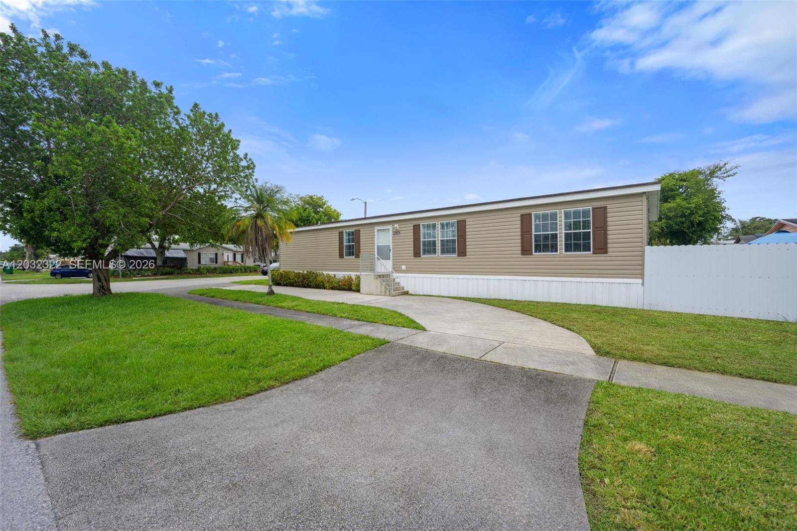One of the best opportunities in West Pembroke Pines! This 2014-built 4-bedroom, 2-bath manufactured/mobile home stands out among active comps as one of the most recently constructed options in the area. Impeccably maintained and move-in ready, with roof, A/C and appliances in excellent working condition. Spacious layout, great natural light and parking for approximately 7–8 vehicles without using the grass — a rare and practical advantage. Land is included in the sale; this is not a land lease. No age restrictions. Enjoy a peaceful residential setting that feels tucked away from traffic, yet remains conveniently close to everyday essentials, shopping, dining, I-75, Pines Blvd, Costco, Publix, Whole Foods and nearby schools including Chapel Trail Elementary, Silver Trail Middle and West Broward High. A smart option for buyers looking for space, ownership, location and value in a well-established Pembroke Pines community.