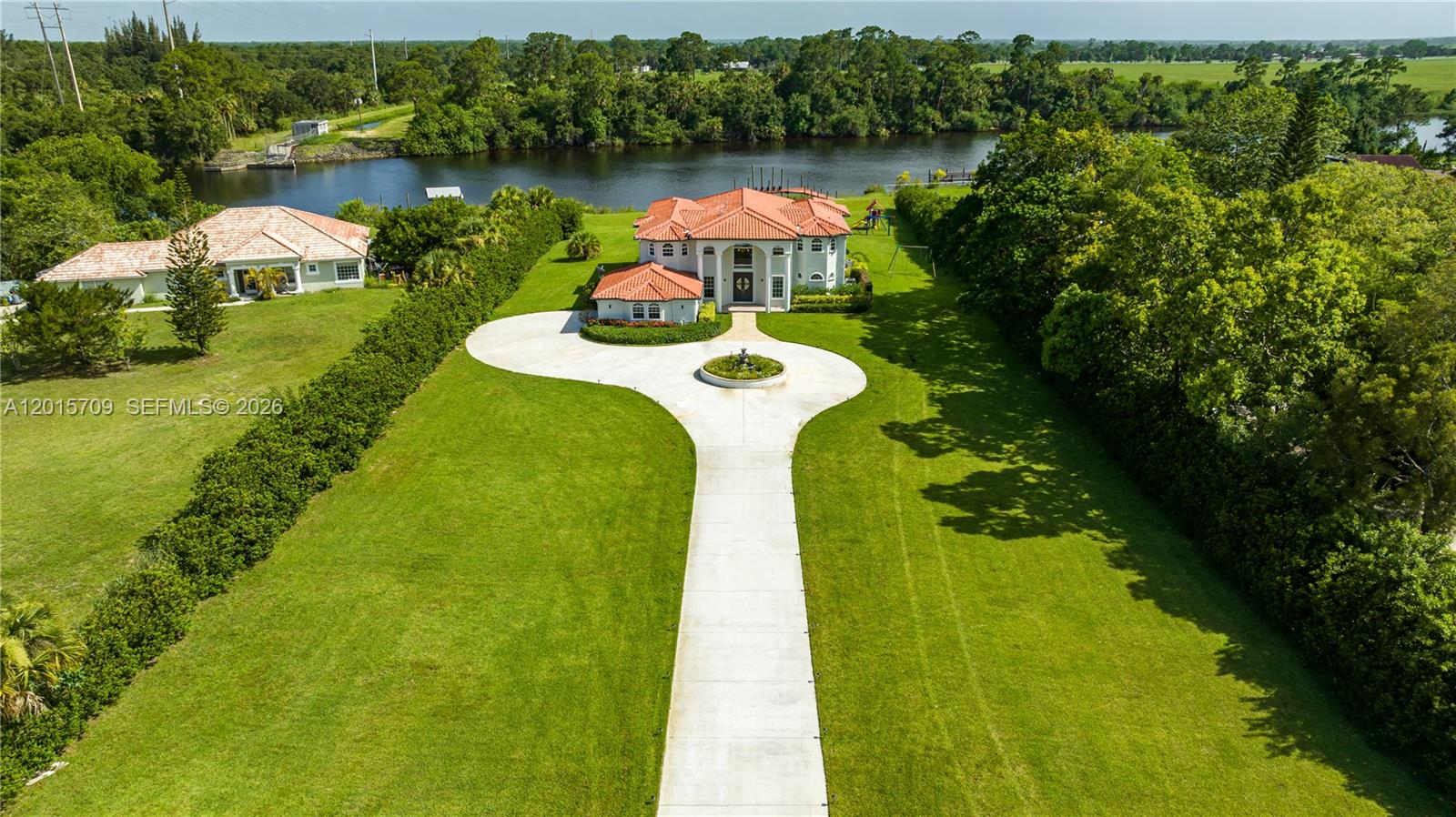 Rare opportunity to own a stunning 9-bedroom, 5-bathroom estate in the heart of Palm City. Built in 2006 and situated on nearly 2.5 acres, this impressive property offers the space, privacy, and lifestyle today’s buyers are searching for in 2026. Surrounded by beautiful greenery and peaceful water views, the home features expansive living areas, abundant natural light, and the perfect indoor-outdoor flow for entertaining or relaxing. The oversized lot creates a true private estate feel while still being conveniently located near shopping, dining, parks, and major roadways. Properties with this much land, flexibility, and character rarely become available, making this an exceptional opportunity in one of Palm City’s most desirable areas.