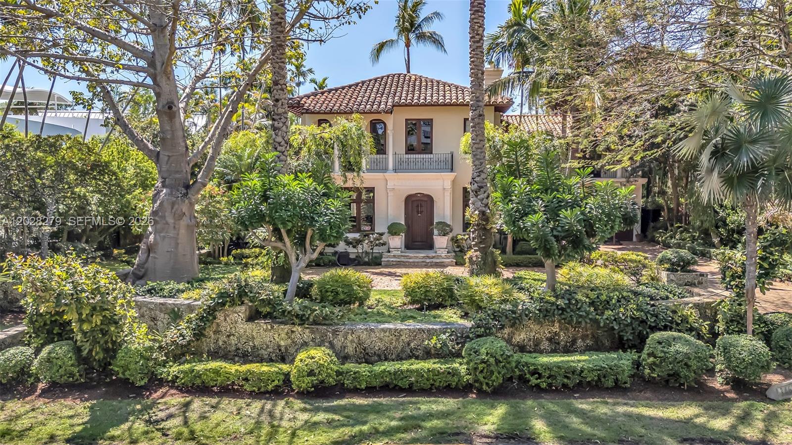 A truly extraordinary home in Coconut Grove's prestigious Moorings community — one of only two Miami neighborhoods with private entry roads and a 24-hour manned guard gate. Abundant common areas, including the iconic 100-year-old Kapok tree at the entrance, reflect the unique and historic character of this community.
Set atop the Coconut Grove Bluff at approximately 18 feet above sea level, the home features timeless Mediterranean architecture, lush landscaping, and exceptional curb appeal. Interiors offer warm natural light, beautifully designed windows, original Cuban tile floors, and elegant architectural details throughout. Sun-filled sitting rooms overlook the gardens, creating bright living spaces ideal for both family living and entertaining. If walkability to Coconut Grove’s finest locales, restaurants, and schools is what you are seeking, you must check out this gorgeous property. 
.