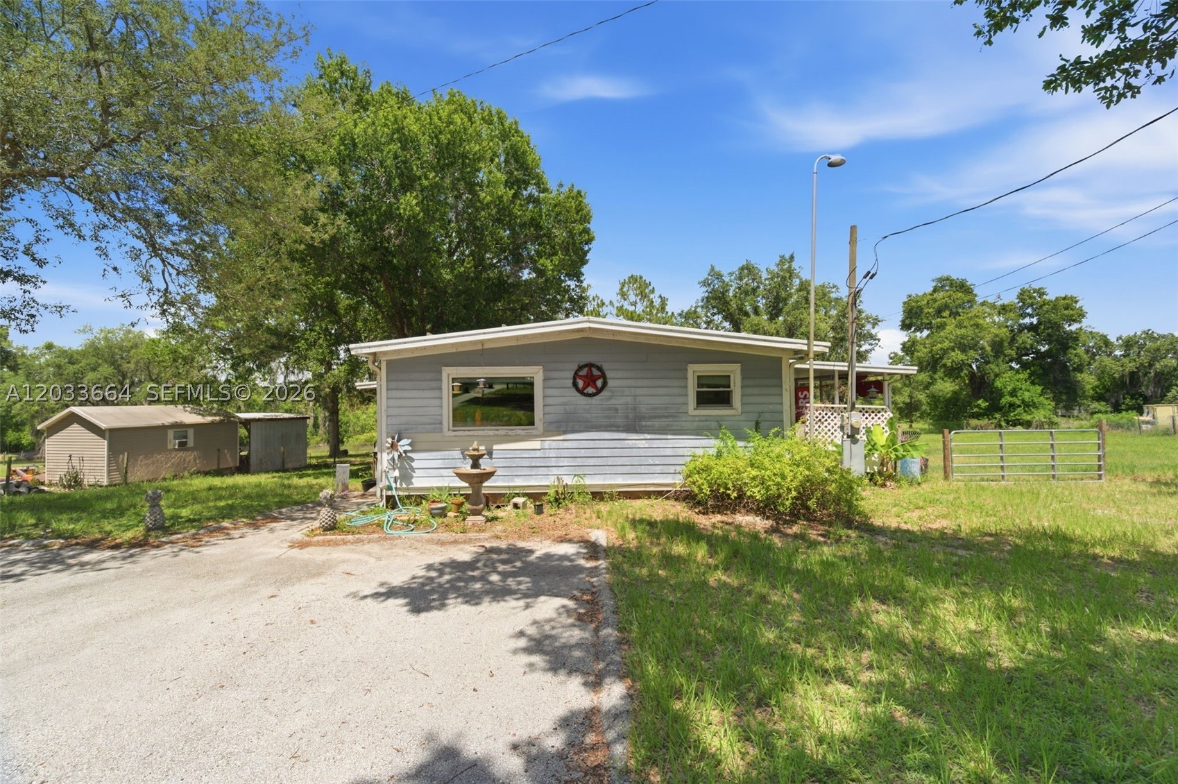 CASH ONLY! Nestled on an expansive 2.46-acre property comprised of two parcels, this unique Polk City retreat offers the perfect blend of privacy, space, and convenience. The 1973 double-wide mobile home is classified as real property and features 2 bedrooms and 2 bathrooms, including a beautifully renovated primary bath and a second bathroom ready for your personal finishing touches. Step inside to find a spacious, oversized primary suite, wood and vinyl flooring throughout, updated plumbing, stainless steel appliances less than five years old, and a newer central A/C system with all ductwork recently completed. The metal roof is also less than five years old, providing peace of mind for years to come. Outside, the possibilities are endless. Enjoy morning coffee on one of two decks overlooking your private acreage, complete with a chicken coop, additional storage buildings, handicap-accessible ramp, and plenty of room for gardening, animals, RVs, recreational toys, workshops, or simply enjoying wide-open Florida living. A convenient doggy door adds extra functionality for pet owners. You'll be just minutes from schools, shopping, restaurants, and everyday conveniences in town. Located only 5 minutes from I-4, commuting is a breeze, with Disney World, Orlando attractions, and major employment centers approximately 30 minutes away. CASH ONLY.