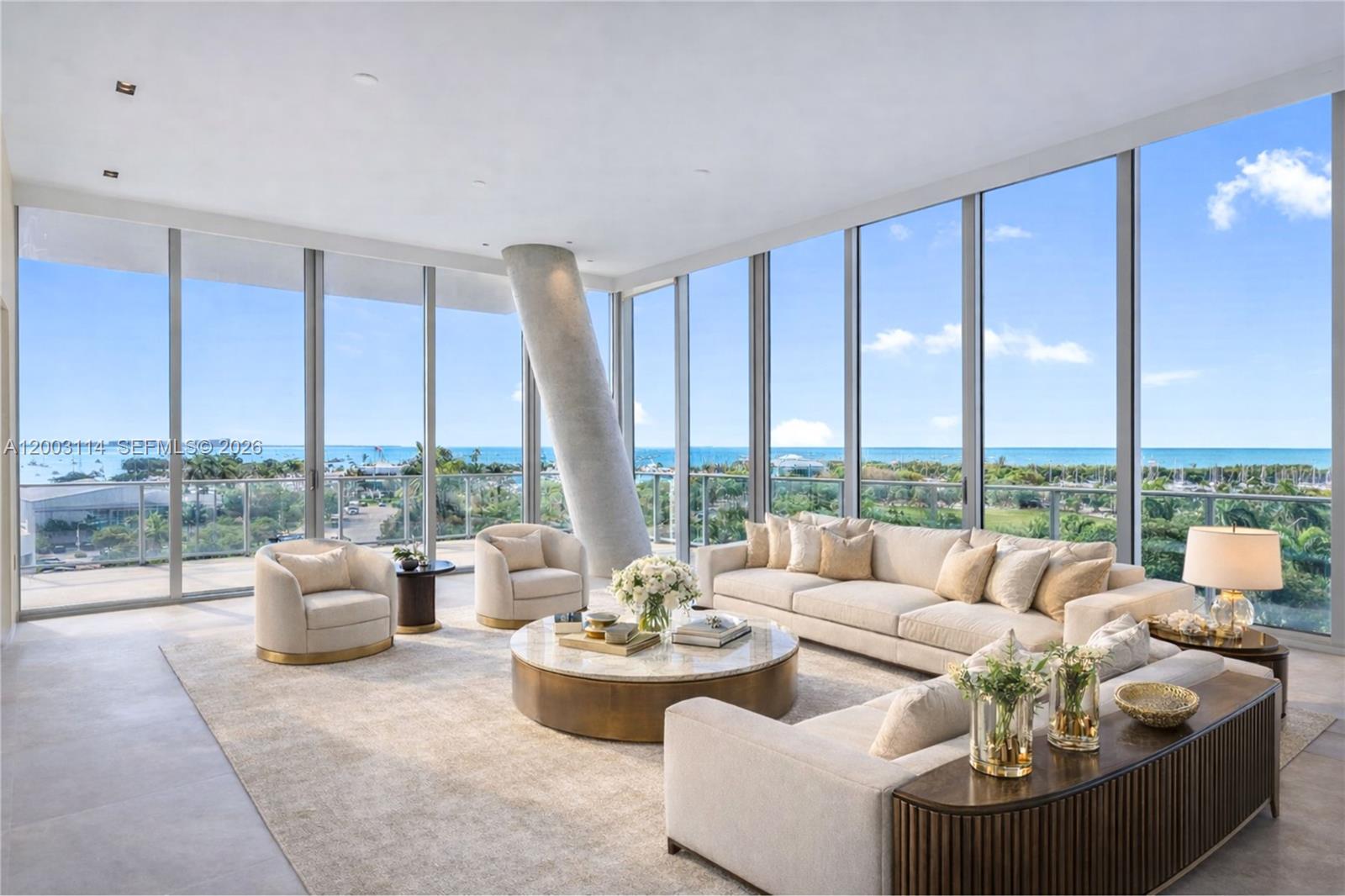 This exclusive listing at Grove at Grand Bay, one of Coconut Grove’s most architecturally significant addresses, presents a 5-bed, 5.5-bath residence spanning total 4,186 SF across a full private floor with direct elevator entry. Twelve-foot floor-to-ceiling glass and a 12-foot-deep wraparound terrace create a seamless indoor-outdoor experience with sweeping views of Biscayne Bay and the Miami skyline. Wood flooring is paired with grey limestone tile, adding texture throughout. The kitchen is thoughtfully designed with custom Snaidero cabinetry and fully integrated Miele appliances, including a gas range, offering both functionality and a clean, modern aesthetic. The primary suite is positioned to capture serene water views and features a spacious walk-in closet and a spa-inspired bath designed for comfort and relaxation.
The Grove at Grand Bay’s signature twisting towers, envisioned by Bjarke Ingels, are set within lush, sculpted gardens by Raymond Jungles. Residents enjoy a curated collection of amenities including full-service concierge, private restaurant, rooftop pool terrace, wellness spa with sauna, state-of-the-art fitness center, glass-enclosed tennis court, chauffeured car service, valet, pet care services, 2 assigned parking and storage.