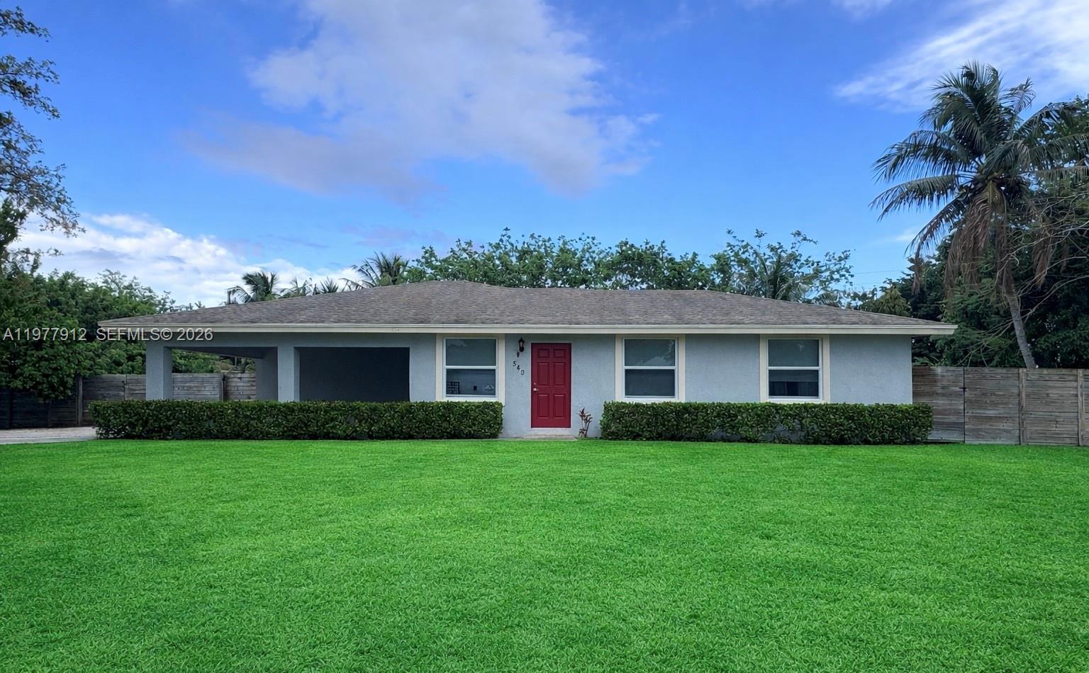 This beautifully built 2018 home sits on an oversized corner lot with plenty of room for a pool and offers 5 bedrooms and 2 bathrooms with a bright open-concept layout perfect for modern living. The stunning kitchen features high-end Wood Harbor cabinetry, granite countertops, stainless steel appliances, and a breakfast bar with seating for four. The spacious primary suite includes an ensuite bath and walk-in closet, while the four additional bedrooms provide comfortable space for family, guests, or a home office. Enjoy hurricane impact windows and doors, covered 2-car parking, a large paved driveway, and tropical fruit trees including 2 coconut trees, 1 apple tree, and 3 mango trees. Built in 2018 with a 2022 water heater and eco-efficient A/C, this home is conveniently located near major highways, the airport, and the beach.