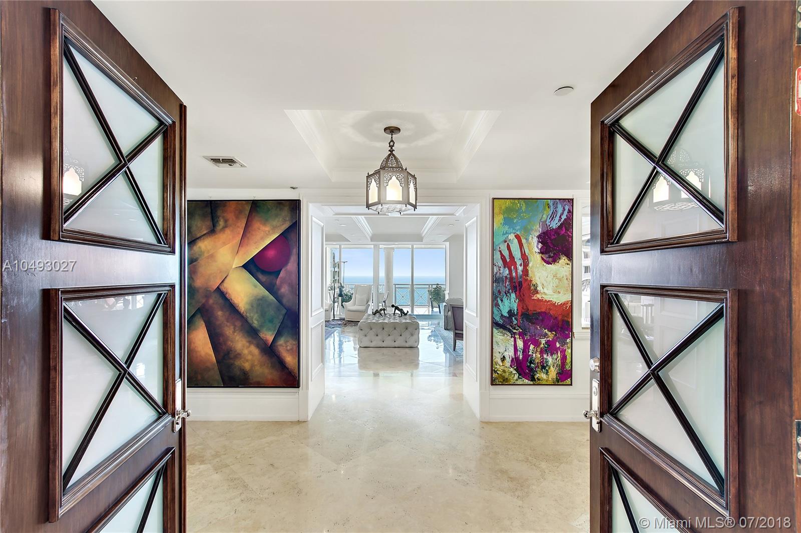 Presenting one of Grand Bay community’s largest luxury units with views of the Ocean and Bay. Just imagine 5634 int. SF, 5 bed, 4.5 baths, and beautiful terraces. A private elevator opens to the double size living room. An art lovers dream! Hector-Hector chef’s kitchen has center island breakfast bar, custom Chippendale cabinetry, top shelf appliances, three ovens and a wine fridge! Dinner can be served in the dining room next to the rustic Library, serving wine from the temperature controlled 1,100 bottle wine room. After a movie in the theater, retire to the Master suite with spacious walk-in closet, spa-like bath, for a soak in the tub. Draw the motorized shades, and enjoy the smart home entertainment system. Includes 2 parking spots, storage, and a 245 SF studio (1/1) on the 1st floor.
