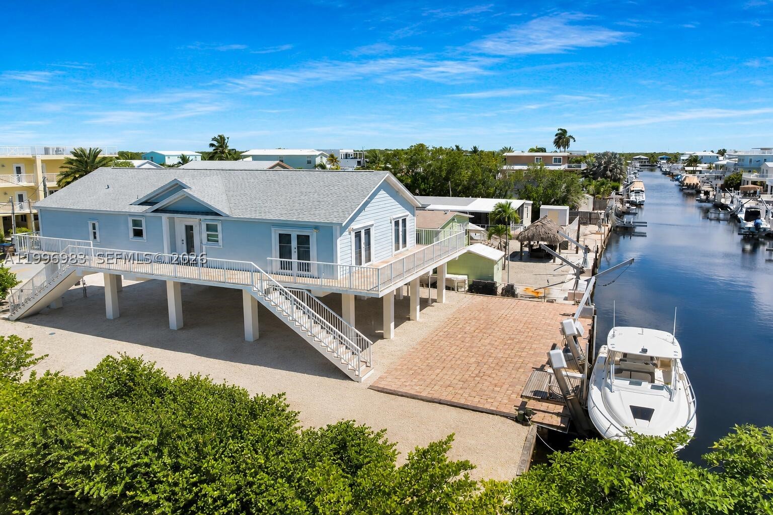 THIS IS FLORIDA KEYS LIVINGT AT ITS BEST!! Truly a Tropical Oasis, this Stunning 3 Bedroom 2 Bath Key Largo Canal Front retreat on a large corner lot with 65 feet of concrete dock & quick access to the Bay and Ocean thru Adams Cut will impress!! This 2006 impeccable home, with all the modern luxuries you could want, features gorgeous engineered wood floors throughout. The open living area is beautifully presented with soaring vaulted ceilings, a huge kitchen island for family gatherings! SS appliances and an induction cooktop. Step into your main bedroom and enjoy the moment in a spa like bathroom where you can unwind and relax. Downstairs you will find a very large patio area under cover perfect for Sunday BBQ's with friends and family.  The 65' foot concrete dock is equipped with a 15,000 lb boat lift just waiting for a new boat! Plenty or room for all your water toys here! Bring your RV, there is plenty of room, this is a large 65 X 100' corner lot. Location! Location! Conveniently located in Lake Surprise, MM 106 Bayside. Absolutely one of Key Largo's premier neighborhoods, close to shopping, amazing restaurants and outdoor water fun. A 20 minute drive to the mainland makes this home  a perfect choice for those seeking the best of both worlds! Long Key Road is the first canal in from Blackwater Sound, you'll be out on the water in seconds. Don't miss this opportunity to own this stunning canal front home in Lake Surprise.