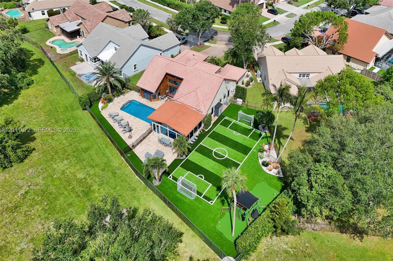 A Private Stadium & Intelligent Fortress. Rarely does a property redefine luxury; this 4-bed, 3-bath estate situated on one of Forest Ridge’s largest pie-shaped lots does exactly that. Backing up to The Ridge—a protected natural reserve with zero back neighbors ever—this compound offers absolute privacy and athletic luxury tailored for the elite. Just in time for the 2026 World Cup, train in your private 3v3 professional-grade TURF SOCCER FIELD, featuring smartphone-controlled stadium-like floodlighting for 24/7 access. The outdoor oasis continues with a private putting green, a Ninja Warrior-style playground, a heated saltwater pool accented by a custom waterfall, chef's dream outdoor kitchen and high-end Ipe wood detailing. Engineered for the security-conscious buyer, the home features a commercial-grade, hacker-protected Unify Dream Machine network with seamless connectivity from the interior to the stadium perimeter. Security is bolstered by impact windows/doors with ceramic heat-reflecting tint, a 22kW full-home generator, and a whole-home alkaline water filtration system (Jan 2026). Sophistication meets scale with porcelain flooring, a 4 face 102” imported Italian tile accent wall, and Versace designer bathrooms. The chef’s kitchen boasts double ovens, a built-in Miele coffee system, and custom cabinetry. Enjoy a seamless lifestyle with smart motorized shades and a fully integrated Sonos whole-home audio system (inside and out), entirely controlled by your smartphone.