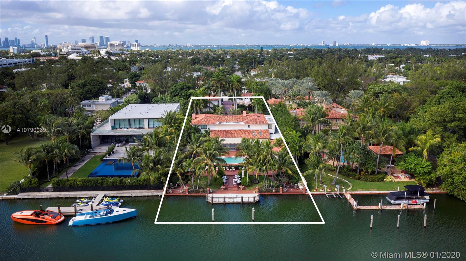 Incredible opportunity to acquire the lowest-priced Estate Lot on coveted Pine Tree Drive. Generous 37,100 Sq. Ft. lot with 100 Ft. of water frontage offering the ability to yield a custom designed, 18,000 Sq. Ft. Estate on prime waterfront property, or choose to update and live in the current Mediterranean style Estate, a 2-story contemporary home featuring details such as fine marble floors in the main living areas, accented by custom ceiling moldings and detailing. The main floor showcases double height ceilings, living room with fireplace, formal dining room, plus separate family and media rooms. The generously sized master suite offers dual spaces with two bathrooms and walk-in closets. The grounds include two private guest houses, pool, outdoor bar, cabana, and outdoor seating areas.