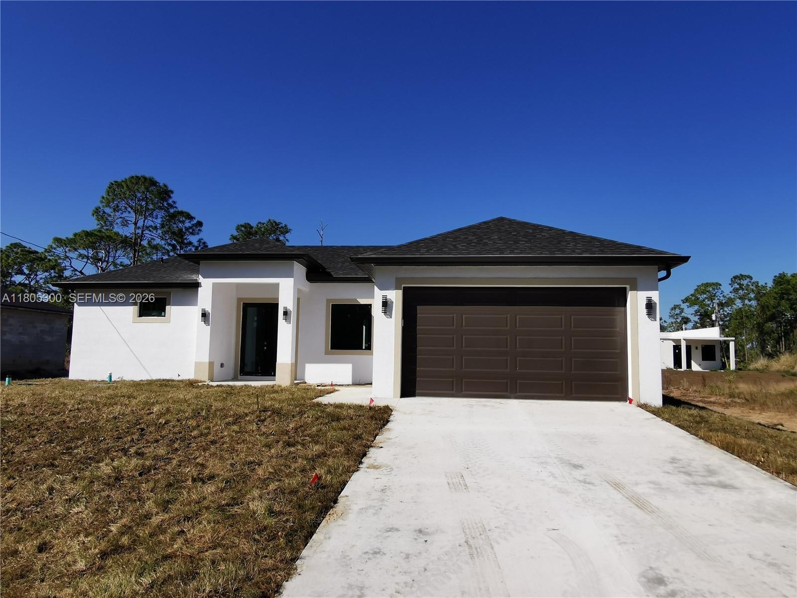 Ready to Move In! Look no more... Don't miss out on this beautiful 3-bedroom, two-and-a-half bath new construction single-family residence in the fast-growing area of Lehigh Acres in Florida. The home features impact-resistant windows and doors with (Low-e) low-energy efficiency glass to ensure safety, durability, and a low electric bill. At the same time, tile floors provide easy maintenance and longevity, along with a brand-new set of stainless steel appliances. The master bedroom offers a his and a her walk-in closet and a spacious master bathroom, while the other two bedrooms are also equipped with walk-in closets. There is an indoor utility room for more convenience. The paved and newly painted driveway leads to a spacious, under-roofed two-car garage, offering ample storage and parking space. The open-concept layout creates an airy ambiance, perfect for entertaining guests or enjoying family time. Located in a prime area near State Road 82, this home provides convenient access to everything and is just a 15-minute drive from Fort Myers. Don't miss the opportunity to make this exceptional property your forever home or your investment opportunity! Hablo Español.