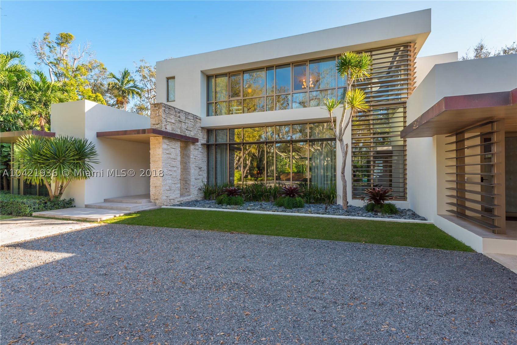 Reminiscent of the work of Richard Neutra, this Mid-Century Modern estate is located in coveted Hammock Lakes. Tucked away and extremely private and secure, the home is poised upon an acre of land, nestled behind Mature Oak Trees and a private Gated Entry. Recently built, the two-story, 7-bedroom home features gleaming marble and wood floors.  Elegantly and stylishly appointed by a top-flight designer, this estate property is perfect for the buyer who wants to move in tomorrow. Features include a Ground Floor Master; large living room with fireplace; dining room with wet bar; gourmet kitchen; spacious pool and deck; lush landscaped grounds; Crestron controlled Smart House; an abundance of natural light throughout the day both indoors and outdoors. NO expense spared in this Custom Home.