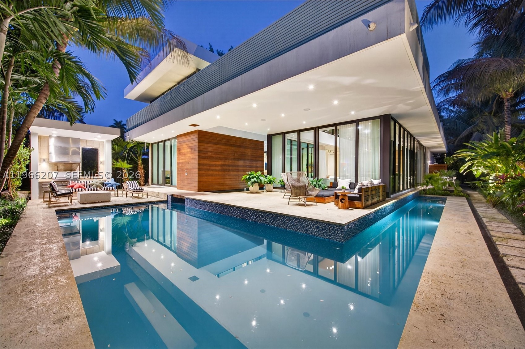 2300 Sunset Drive is a tropical modern six-bedroom, eight-bathroom home on Sunset Island 3 in Miami Beach — one of only two guard-gated island communities you can actually walk from to great restaurants and boutiques. Set on a 13,500-square-foot lot, this move-in ready residence blends clean architecture with warm, organic finishes and effortless indoor-outdoor living.

All six bedrooms are en suite, and every bathroom is wrapped in floor-to-ceiling marble for a true spa feel. White oak floors run throughout, and the chef’s kitchen is equipped with premium Miele appliances. Walls of glass overlook lush tropical landscaping and tranquil water features, giving the entire home a five-star resort vibe reminiscent of Aman or Four Seasons.

The pool wraps around the house, creating a dramatic, resort-style setting that connects every space. Two expansive private sun decks, a built-in barbecue, and a natural keystone patio and driveway complete the outdoor experience. With so many indoor and outdoor spaces surrounded by water and glass, the home feels like a true architectural showpiece.

And the real luxury? Security and privacy. Living on a guard-gated island means peace of mind — while still being right in the center of Miami Beach. It feels like your own private tropical island, just minutes from everything.