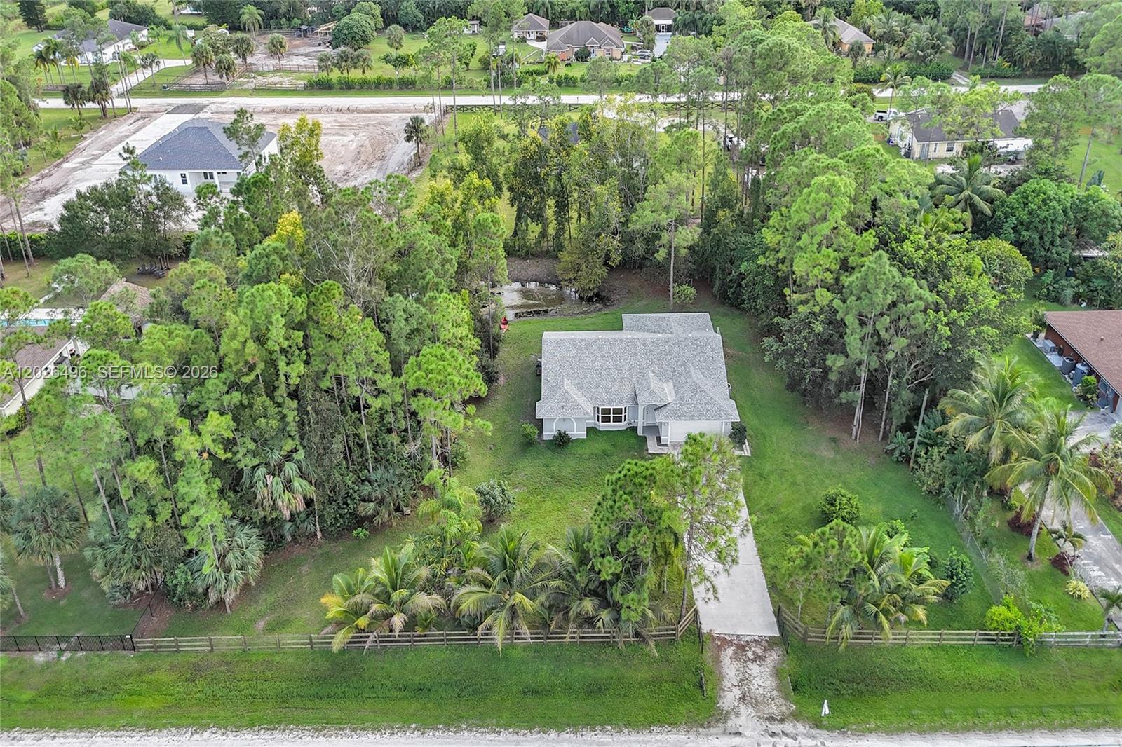 Lovingly maintained by its original owners, this true 4-bedroom, 2-bathroom single-family home sits on over 1.15 pristine acres in the highly sought-after Acreage of Western Palm Beach County. Offering a spacious 2,800 total sq ft with an ideal split floor plan, this move-in-ready residence boasts exceptional peace of mind with a new roof, new water system, and new water heater all completed in 2024, alongside a newer central A/C and reverse osmosis filtration system. The septic tank was just professionally pumped in 2026. Step inside to find exquisite Italian tile running through the main living spaces, brand-new carpeting in the family room, a fresh exterior paint job, and beautifully updated bathrooms. The open kitchen features a huge walk-in pantry, perfect for home chefs. Step outside into your own private tropical paradise, fully fenced with a lush, mature natural border ensuring ultimate privacy. The expansive yard is an orchard lover's dream, featuring abundant coconut palms, pines, mango, mulberry, jackfruit, banana, avocado, Hawaiian plantain, Grapevine, cherry, fig, papaya, and both key and mandarin lime trees. Complete with a large storage shed and an expansive 2-car garage, this NO HOA property offers the perfect rural escape while remaining just a 5-minute drive from grocery stores, local shops, gyms, and dining. Don't miss this rare opportunity!