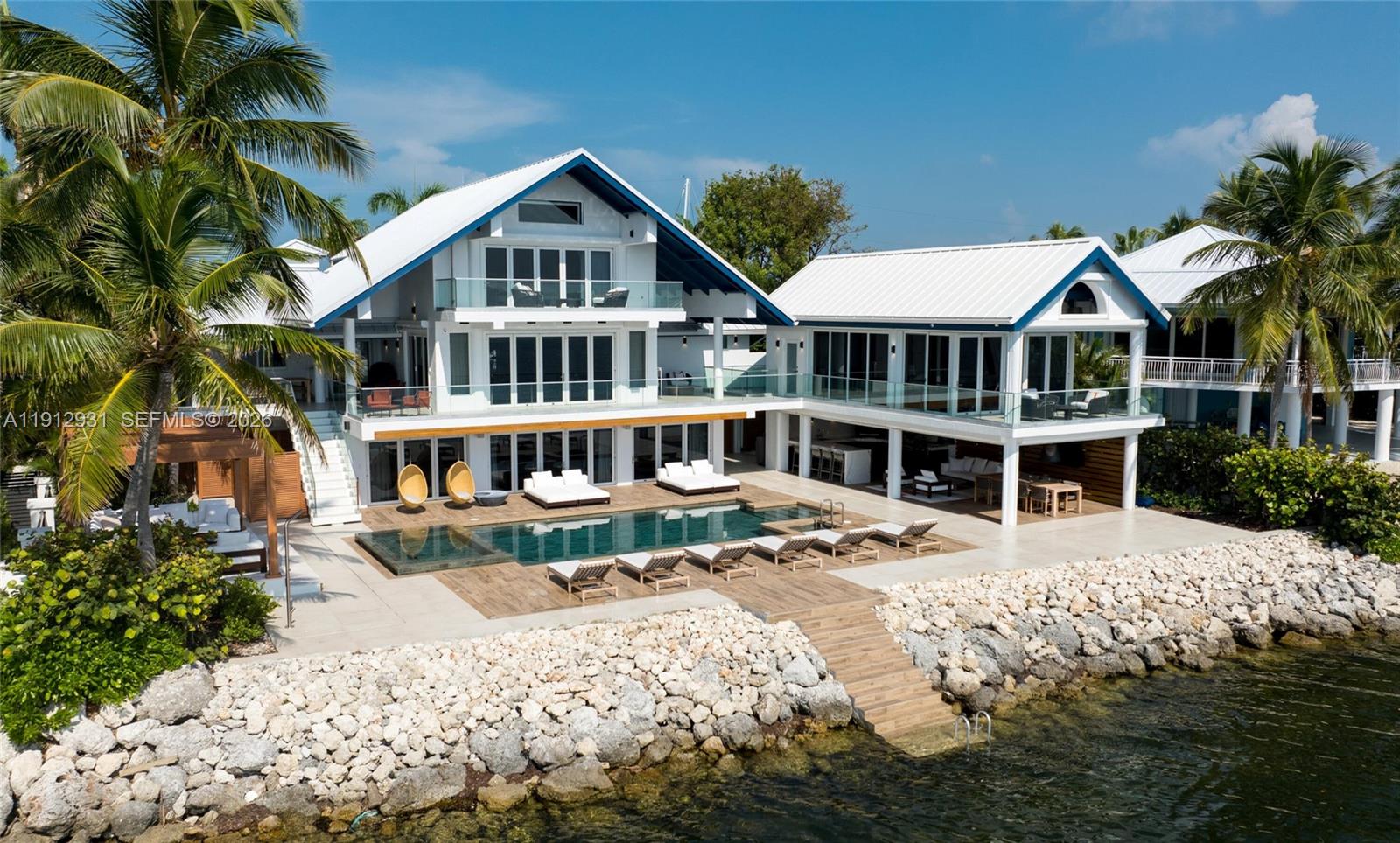 Modern Coastal Masterpiece, luxury ocean front residence with curated design and finishes, inspired by the sleek sophistication of a superyacht. Set within Ocean Cay, an exclusive gated enclave just one hour from Miami yet worlds apart, the property offers 100 feet of deep-water dock and immediate ocean access and an address prized by discerning yachtsmen and collectors of extraordinary homes. Inside, a sculptural floating cypress staircase, enclosed in glass, introduces the main living level. The Upper Salon, a serene retreat with extraordinary open water views, opens to a dining space defined by reclaimed teak ceilings and whitewashed oak beams. The custom kitchen, executed with yacht-like precision, balances elegance with performance through Italian porcelain,