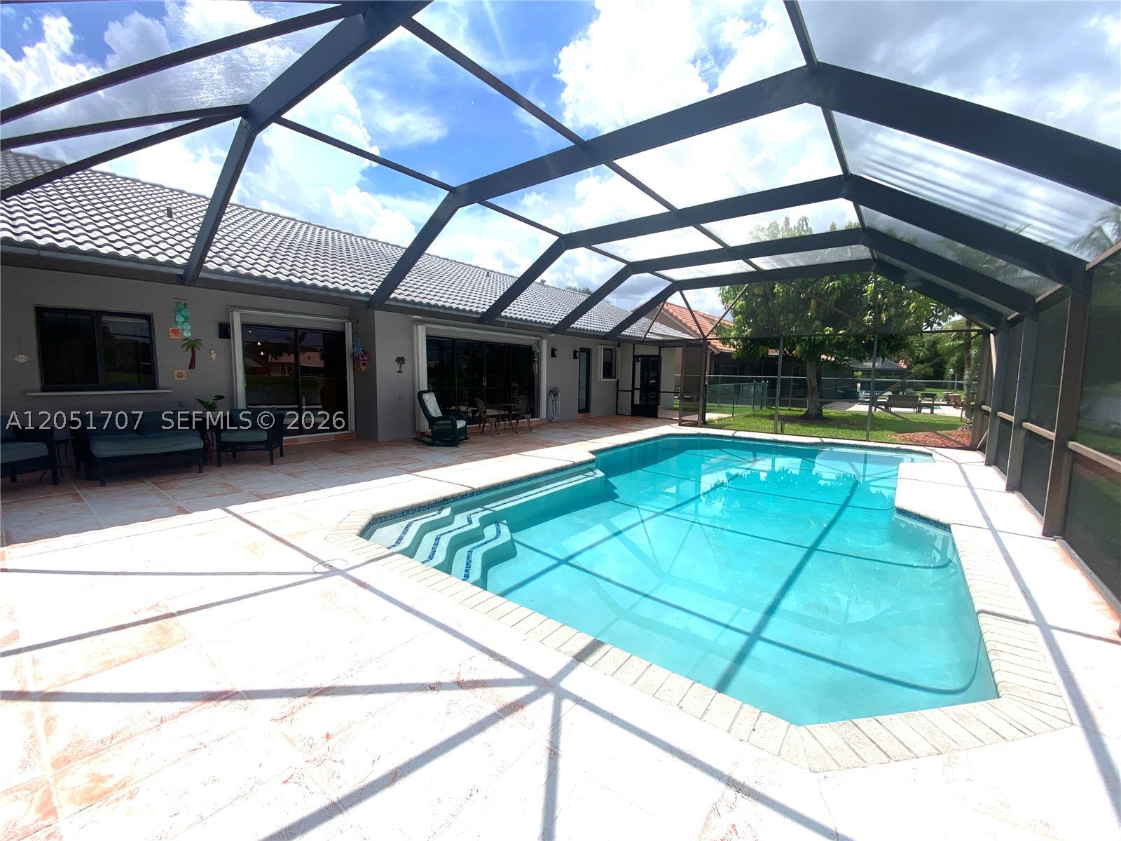 Designed with both comfort and functionality in mind, this waterfront home offers four bedrooms, two bathrooms, and a two car garage with 2400 SF living space. This exceptional property boasts soaring ceilings, a custom oversized pool with two swim outs, a jacuzzi (not the brand) with jets creating the perfect outdoor retreat.  The spacious backyard offers a peaceful setting, and the screened in area also functions as an extension of the property.  The ample primary bedroom has ian impact sliding door that is stunning, beautiful flooring, and the principal bath is spacious with a lovely view of the backyard. The home features both impact and sliding shutters.  Bright, and light!