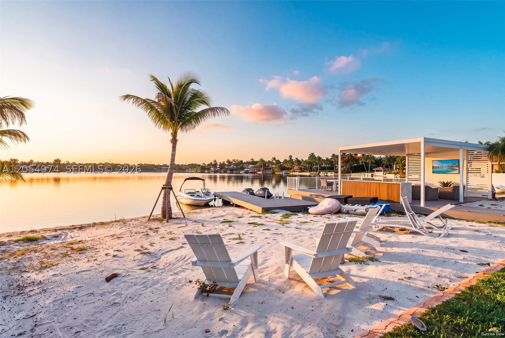 Paradise Found! Spectacular wide lake views showcase this exceptional 22,800 SF private waterfront estate featuring a beautifully remodeled 4-bedroom, 3-bath residence. Thoughtfully designed with elegant designer finishes and a gourmet kitchen appointed with premium appliances, the home blends timeless style with modern comfort. Step outside to your private resort, where a sparkling pool overlooks the lake, an expansive dock with a wet bar invites effortless entertaining, and a separate dock with a boat slip. Jet Ski pad, and private boat ramp provide seamless access to endless boating and water sports. Complete with a sandy beach, this is South Florida waterfront living at its finest.