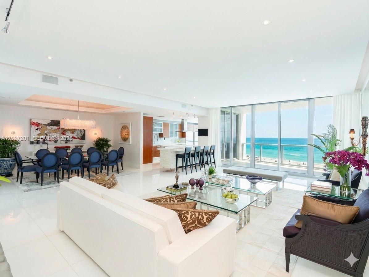 Welcome to Residence 906 at The Bath Club! One of Miami Beach's most coveted addresses on Millionaire's Row. This direct oceanfront residence offers 4,135 Sq.Ft. of impeccably finished living space with 4 bedrooms, 5.5 bathrooms, and sweeping unobstructed  white-sand beach views from every main living area. Soaring 10-foot ceilings and floor-to-ceiling impact glass create a light-filled, resort-caliber atmosphere throughout. The chef's kitchen features custom walnut cabinetry, thick marble countertops and backsplash, Miele built-in espresso machine, stacked wall ovens, professional induction cooktop island, and Sub-Zero refrigeration. A dedicated media/family room showcases a 120-inch screen projector with ambient lighting and integrated in-ceiling surround sound. The oceanfront terrace is ideal for entertaining. Full designer furniture package included, true turnkey/move-in ready delivery. Residence includes two assigned parking spaces. Situated within a gated 5.3-acre enclave featuring 540 feet of pristine Atlantic Ocean beachfront, The Bath Club offers 5-star amenities: private beach service, resort pool, clay tennis courts, health spa, valet, 24-hour security, concierge, and in-residence dining. The "06" line is one of the most sought-after floor plans in the building. A rare opportunity to acquire one of the largest, best-finished residences at the prestigious Bath Club.