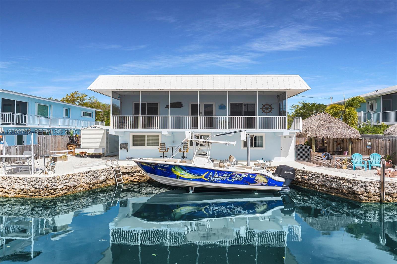 CANAL FRONT - DIRECT OCEAN ACCESS!! Welcome to an experience in lifestyle. Coveted by many but enjoyed by a select few, this unique upper Keys location is surrounded by protected land preserving the natural beauty of these beautiful islands! The cut in dock basin complete with a 10k boat lift makes those days on the water a breeze. Coastal luxury is the theme on the main level from the kitchen's granite counters and stainless-steel appliances to the soothing canal side primary bedroom. Wake up every morning with the sun sparkling over the water. Enjoy the sea breeze on the screened porch, a perfect way to start your day! The custom walk-in closet (could revert to a bedroom) is sure to please! Working from home? Enjoy a canal side office with views most only dream of! The main level also boasts 2 lovely, updated bathrooms as well as ample pantry storage. Entertaining family or friends? The lower level with its own private access is ready for guests with a super comfy living/dining area, a bedroom and bath plus a convenience kitchen with tons of additional storage. Leading right out to the chickee lounge and patio area, this lower level is perfect for all of your entertainment desires. Plenty of parking space for 6 cars plus a boat trailer or an RV (with external power already installed). With so much to offer, the super well-maintained home should be at the very top of your must-have list! Come and see for yourself before someone else lives this dream!