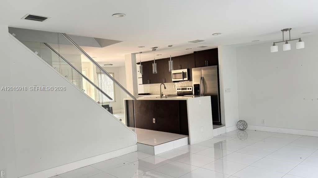 Welcome to your new home in the heart of Plantation! This bright and beautifully remodeled 3-bedroom, 2.5-bath townhome offers a perfect blend of style and comfort. Enjoy sleek porcelain flooring throughout the main living areas, while the bedrooms feature rich dark wood floors that add warmth and elegance. The fully equipped modern kitchen boasts white quartz countertops and stainless steel appliances, complemented by a stunning staircase that adds architectural charm. The spacious layout includes ample walk-in closets and a charming private patio—ideal for entertaining friends and family. Located in the desirable Townhomes at Jacaranda community, residents enjoy access to a pool, clubhouse, tennis courts, and convenient visitor parking. Ideally situated near major highways, shopping, and dining, this home truly has it all.