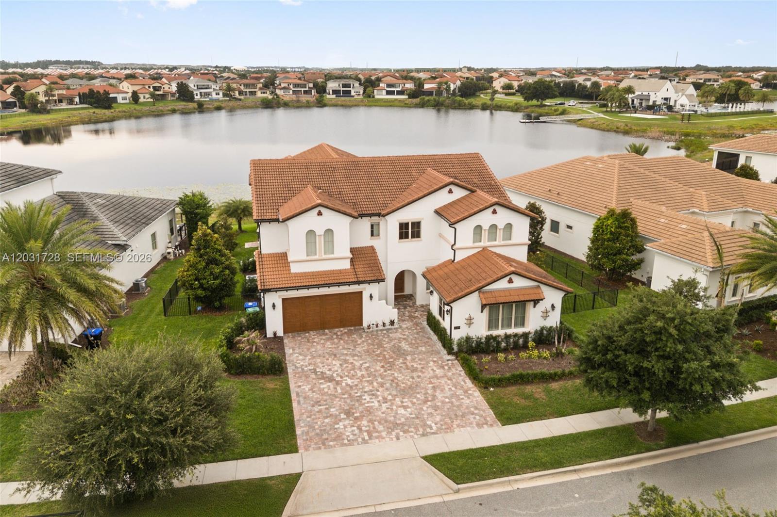 Lakefront living doesn't get more refined than this. Set within the sought-after Lakeshore community in Winter Garden, just minutes from Disney, this residence was designed with intention from the ground up. The main level flows seamlessly from a chef's kitchen into a generous living space, anchored by custom slatted wood panels with integrated lighting. A private en-suite bedroom, dedicated office, and powder room complete the first floor. Outside, a resort-style pool, outdoor kitchen, built-in grill, and unobstructed lake views create the ultimate setting for entertaining. Upstairs, two full suites flank a luxurious primary retreat featuring a custom walk-in closet, spa-inspired bath, freestanding soaking tub, oversized shower, and private lake-view balcony. An expansive media room provides additional space for entertainment and relaxation. Every finish was chosen. Every space was considered. This is the kind of home you stop comparing others to.