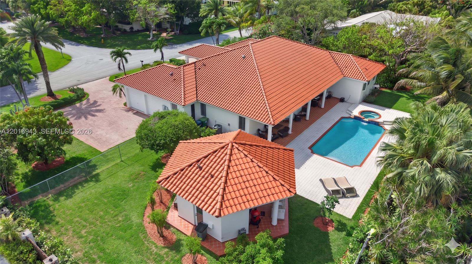 Located on a quiet street near some of the area’s top-rated public and private schools, this beautiful one-story pool home sits on an oversized 19,800 SF lot with expansive green space and offers the perfect blend of comfortable indoor living and exceptional outdoor entertaining. Soaring cathedral ceilings enhance the spacious living areas, while the pool and jacuzzi, along with a covered outdoor kitchen gazebo featuring a fully equipped BBQ area and additional half bath, create a true backyard retreat. The spacious kitchen includes stainless steel appliances, granite countertops, and an open breakfast area overlooking the pool. Additional features include impact windows, two tankless water heaters, two newer A/C's, a full laundry room, 2-car garage, circular driveway, and a fully fenced yard for added privacy and security. Conveniently located near Deering Estate, Deering Bay Yacht & Country Club, and Black Point Park and Marina.