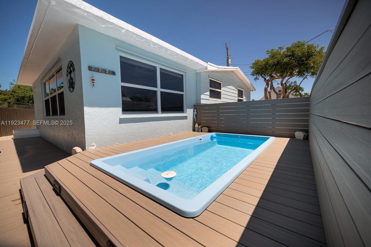 Welcome to your dream island getaway in the highly sought-after Bluewaters community. Nestled at the south end of Key Largo, this 1974 doublewide manufactured home has been transformed into a delightful oasis. Upgraded with impact windows, wood plank tile throughout, newer kitchen with stainless appliances, quartz counters, tile backsplash, and a built-in banquette; both bathrooms have been fully updated with bright white tile and feature glass shower doors for a modern, clean look. An above-ground pool was an excellent addition to the backyard, offering a refreshing escape during the warm summer months. Outdoor aluminum pergola. For boating enthusiasts, the property includes 20 feet of dockage on a deepwater canal with direct ocean access.