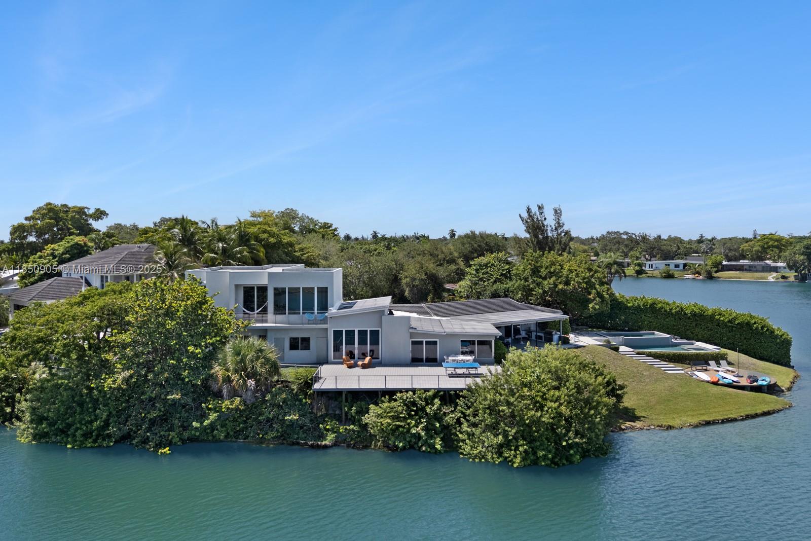 Completed in 2013 this lakefront estate sits on a 13,300 SF island on a private cul-de-sac! Modern 6,894 SF residence offers 6 spacious bedrooms with en-suite baths and walk-in closets, cabana bath and powder room. Bold design meets refined luxury with exposed concrete, soaring ceilings, floor-to-ceiling windows, flush soundproof doors, and a Mia Cucina kitchen. Oversized primary with dual walk-ins, spa bath, lake views. Formal living room, double family rooms, playroom, cellar, and dining room, custom buffet/bar, the perfect blend of function and style. Chef’s kitchen with island seating and breakfast nook. Entertain outdoors on the expansive patio with BBQ, new deck, double pool + Jacuzzi, cold plunge, and turf area under a mature avocado tree. Experience top-tier design and tranquility