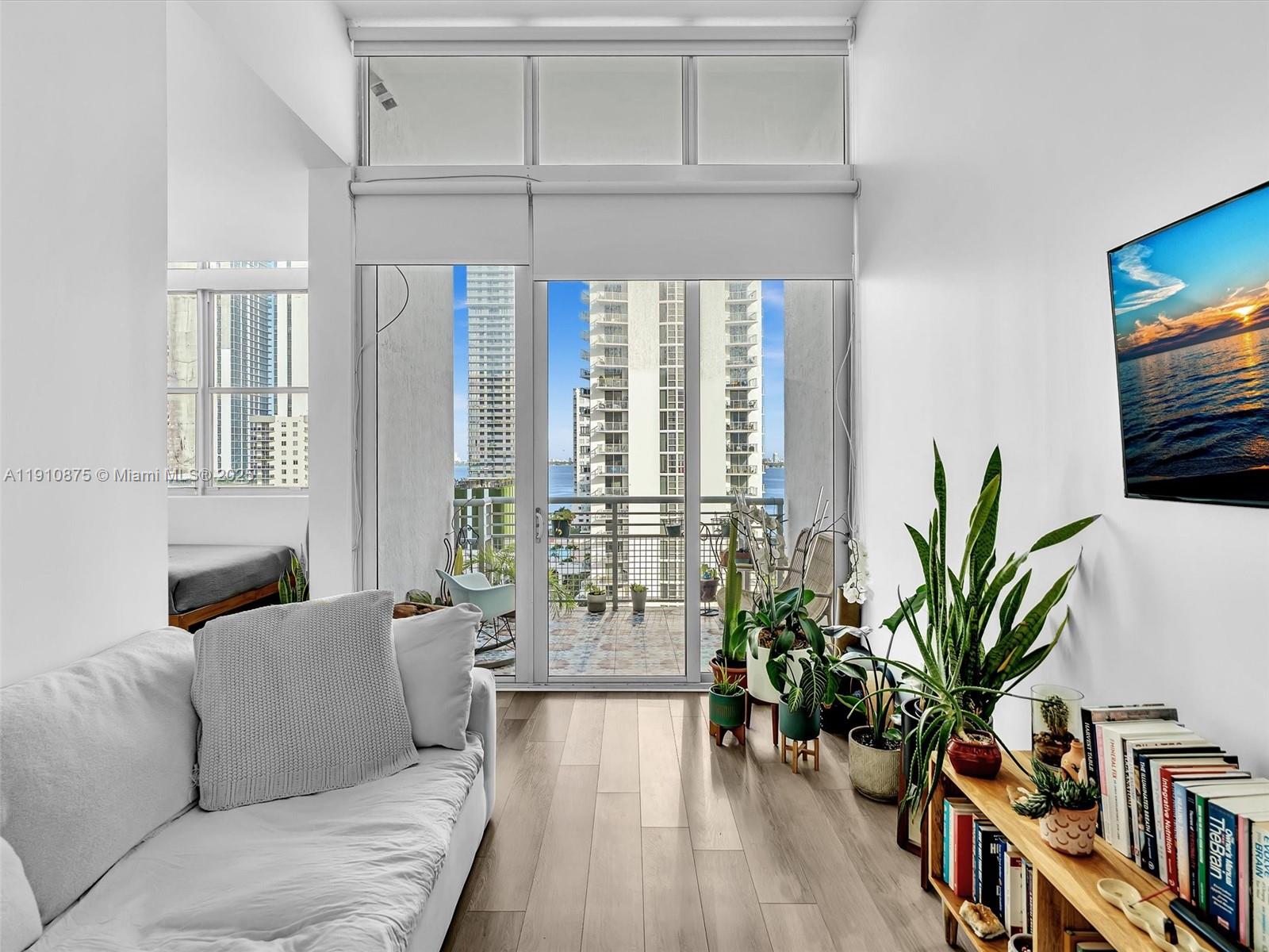 Step into this stunning penthouse and feel instantly at home. From the moment you enter, the sparkling bay views draw you in, framed by soaring ceilings and beautiful light wood floors that make the space glow. The open-concept design flows effortlessly from the modern kitchen with stainless steel appliances to the inviting living area—perfect for relaxing or entertaining. The spacious den offers the flexibility of a home office or guest retreat, and you’ll love the convenience of your in-unit washer/dryer and self-assigned parking. Edgewater Lofts offers the best of Miami living—a refreshing pool, gym, sauna, and jacuzzi, all just steps from the water, parks, and trendy cafés. This is more than a home—it’s a lifestyle filled with light, views, and the energy of the city at your doorstep.