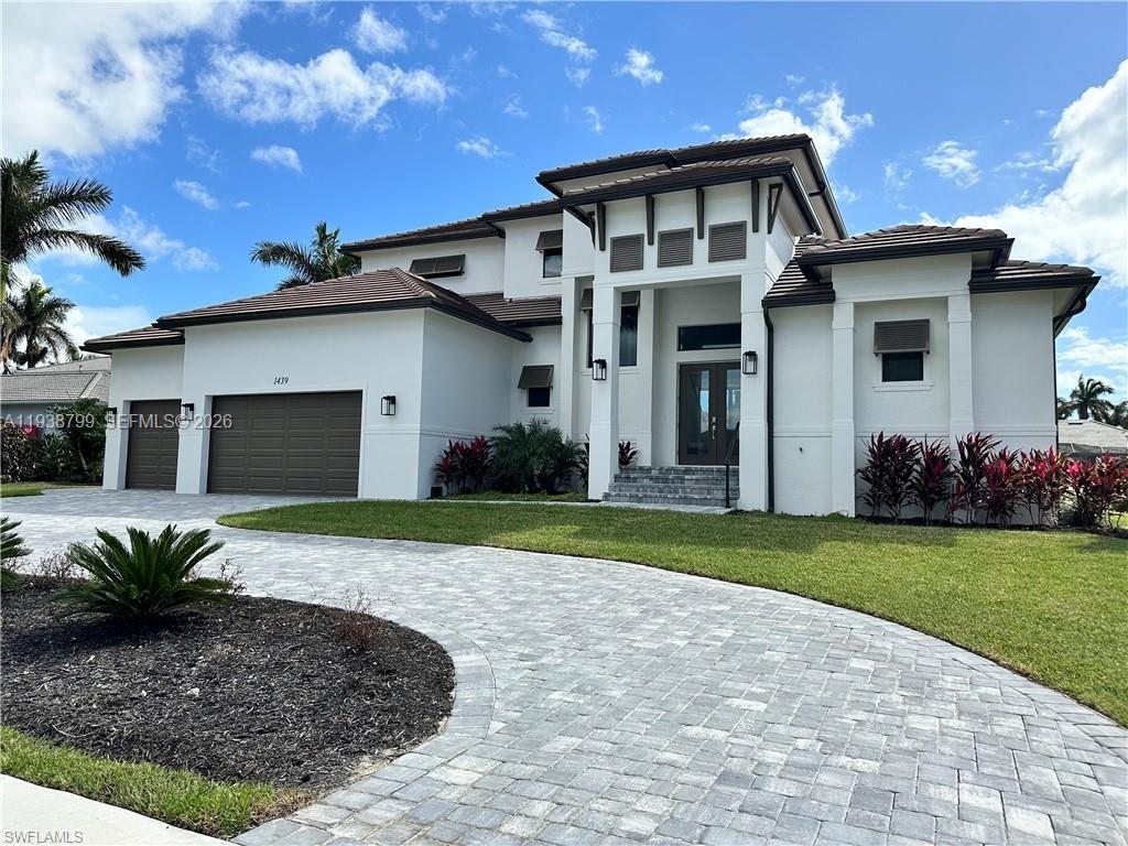 Welcome to an exceptional new-construction waterfront residence in the heart of luxurious Marco Island. This two-story coastal retreat offers 5 bedrooms plus a den, 4 bathrooms, and a striking metal roof that delivers both architectural beauty and superior storm protection. Currently under construction, this home is thoughtfully designed to capture the very best of waterfront living. Expansive open-concept living areas are filled with natural light and flow seamlessly for both everyday comfort and entertaining. The kitchen connects effortlessly to the dining and living spaces and features a large walk-in pantry with custom shelving. A well-appointed laundry room with cabinetry and utility sink is conveniently located just off the garage. The primary suite is a private sanctuary with double doors opening directly to the pool, dual walk-in closets, and peaceful water views. The spa-inspired en-suite bath features double vanities, a multi-head shower, and a freestanding soaking tub. Upstairs, a second-floor balcony offers panoramic canal views, the perfect setting to unwind and enjoy Marco Island’s legendary sunsets. Step outside to your resort-style pool overlooking the canal, complete with direct Gulf access for boating, fishing, and sunset cruises. This exceptional property blends modern coastal elegance with the ultimate island lifestyle. A rare opportunity to own a brand-new luxury waterfront home on Marco Island.
