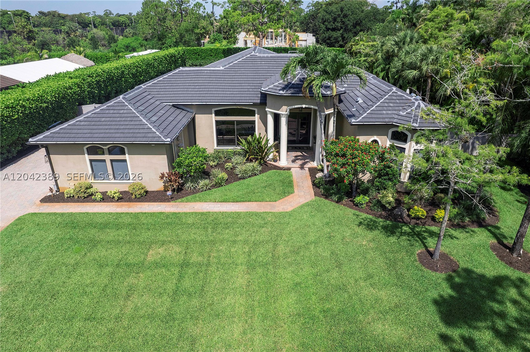 Magnificent completely polished 5 Bedroom 3 bathroom estate home on 1 acre in Prestigious Pine Tree Estates with no HOA! Lush meticulously manicured landscaping, massive driveway, three car garage with 3,232 square feet, 14 foot ceilings, gourmet kitchen, premium appliances, quartz countertops, and marble floors throughout the main living area! BRAND NEW 2025 ROOF and BRAND NEW IMPACT WINDOWS with amazing sun filled lighting in every room. Designed for both comfort and entertainment, private patios views resort style pool, sports court for pickleball and basketball, in-ground trampoline, and land. This home is truly one of kind.