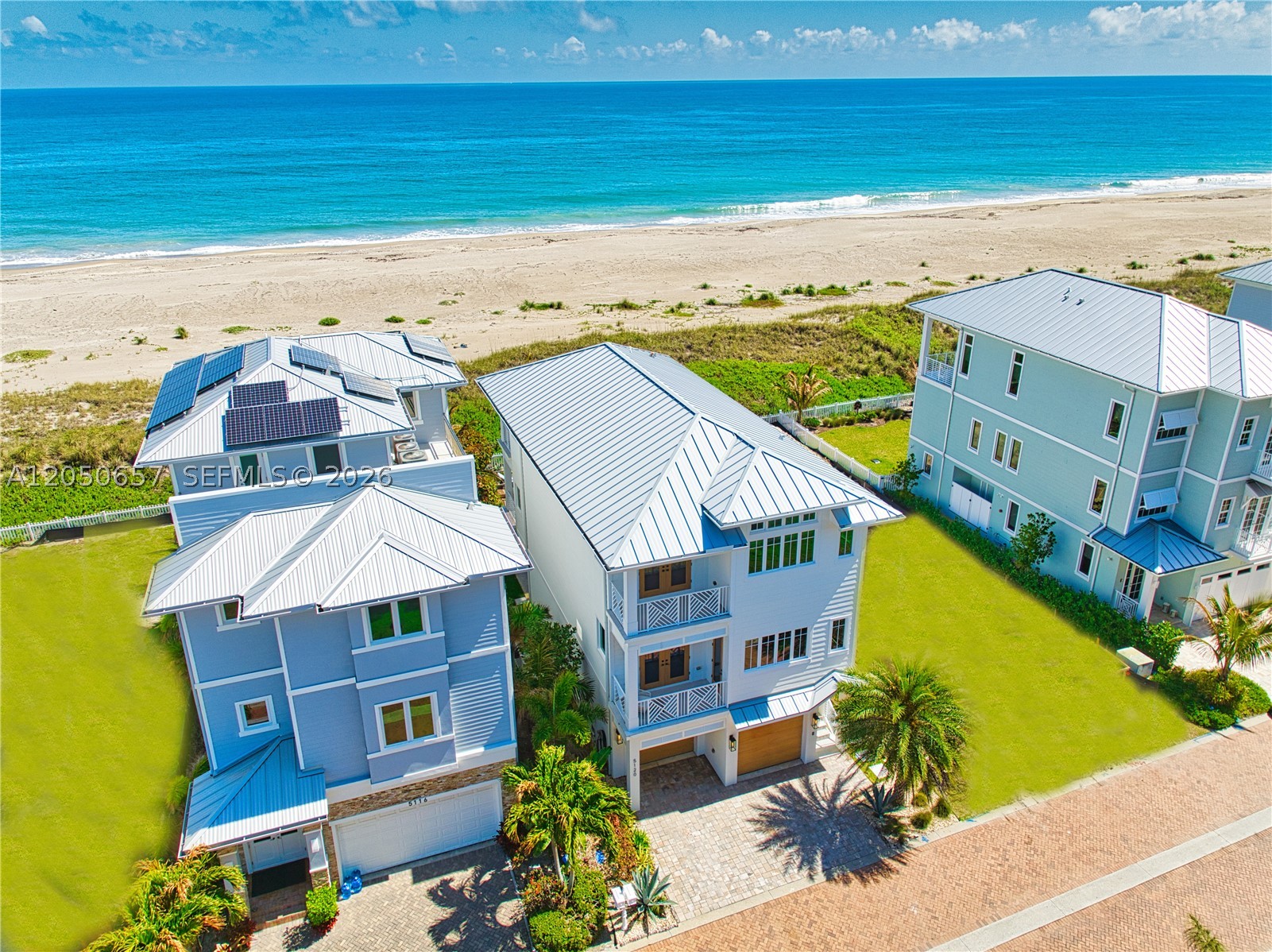 Experience modern coastal luxury in this stunning 2021 custom-built oceanfront retreat located in the exclusive gated community of Watersong on South Hutchinson Island. This 4-bedroom, 3-bath residence with a den/office features a thoughtfully designed floor plan centered around a chef’s kitchen with premium cabinetry, professional-grade appliances, gas range, and an oversized island perfect for entertaining. Soaring ceilings, durable luxury vinyl flooring, and expansive hurricane-impact windows fill the home with natural light while showcasing breathtaking ocean views. The primary suite is a private coastal sanctuary featuring its own balcony overlooking the Atlantic, two oversized walk-in closets, and a spa-inspired bath with a soaking tub, expansive wet-room shower, and dual vanities. Wake up to spectacular sunrises over the ocean and unwind each evening with colorful sunsets over the Intracoastal. Outdoor living is designed for the ultimate island lifestyle, complete with an outdoor shower, hot tub, gas fireplace, workout area, and pass-through garage doors ideal for storing a midsize center console boat or multiple jet skis. An elevator provides easy access to all levels. The private, quiet community offers both security and serenity, along with a resort-style pool perfect for swimming laps or entertaining guests. Schedule your private tour today and start living the South Hutchinson Island lifestyle.