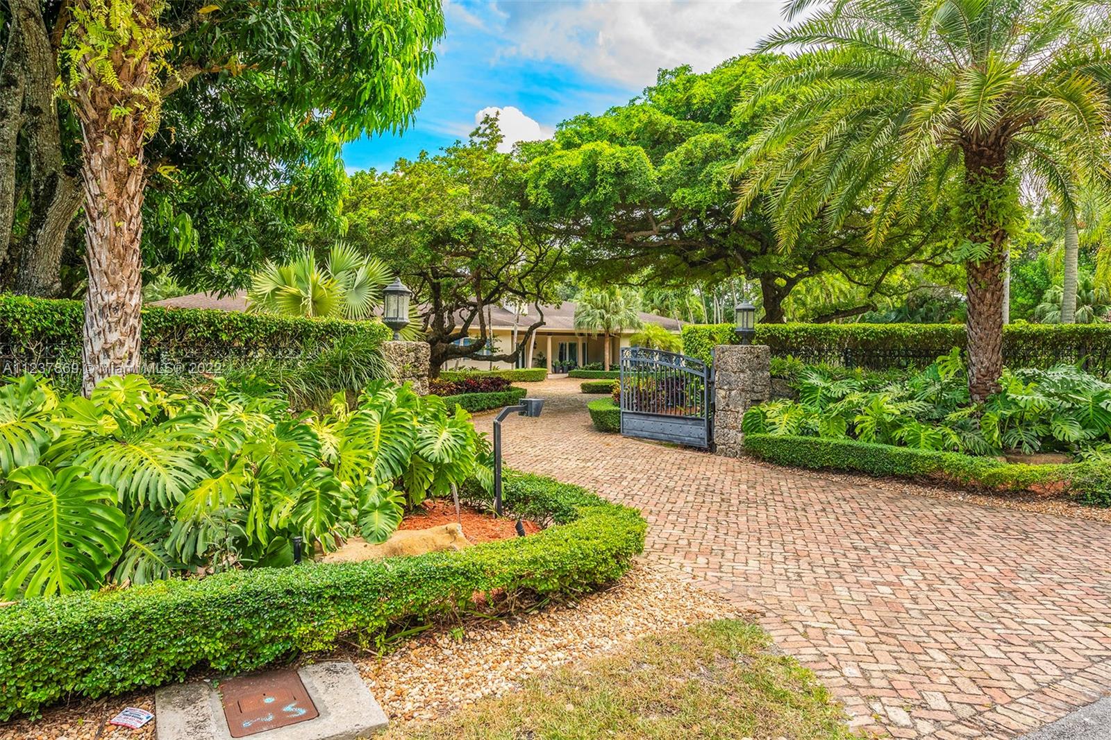 Exquisite & Elegant! This stunning transitional & renovated north Pinecrest Gem sets on a picturesque, lushly landscaped acre, surrounded by amazing wonder of nature, under mature & majestic tropical trees & plantings. Superlative designed with fabulous floor plan featuring 5 ensuite bedrooms plus office, familyroom, playroom, two patios, 3 car garage (airconditioned)! Beautiful formal living & dining. Gourmet chef's dream kitchen w/top-of-line appliances. A full wet bar coupled in the familyrm.  Lavish master with luxurious bath & an incredible walk-in closet! Gorgeous Pool/patio with summer kitchen & cabana bath! Additional basketball court! Luxurious & finest detailed appointments in every turn! All-encompassed in this coral-rock walled & gated piece of paradise! (See Broker's remarks)